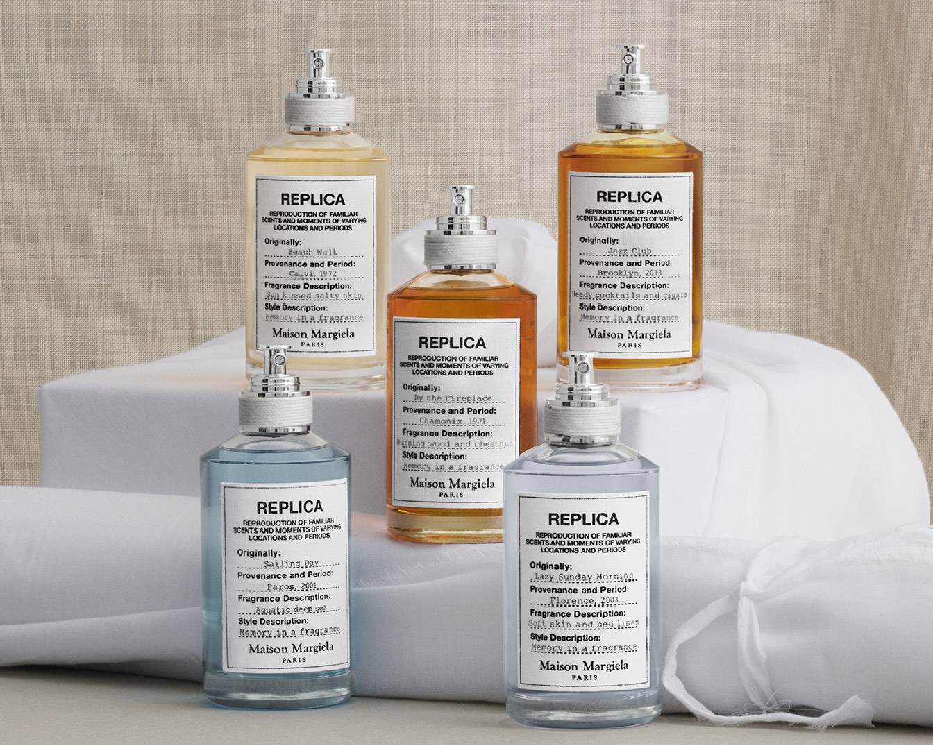 Prezentacja kolekcji zapachów Maison Margiela REPLICA, każdy w przezroczystej butelce z etykietą opisującą inspirację: Beach Walk, By the Fireplace, Jazz Club, Sailing Day i Lazy Sunday Morning.