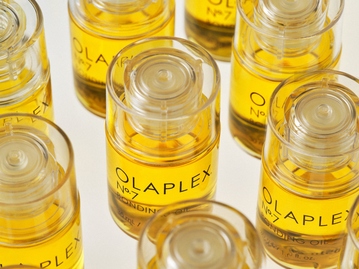 Zbliżenie na buteleczki Olaplex No. 7 Bonding Oil, wypełnione złotym olejkiem, obiecujące wzmocnienie i blask Twoich włosów.