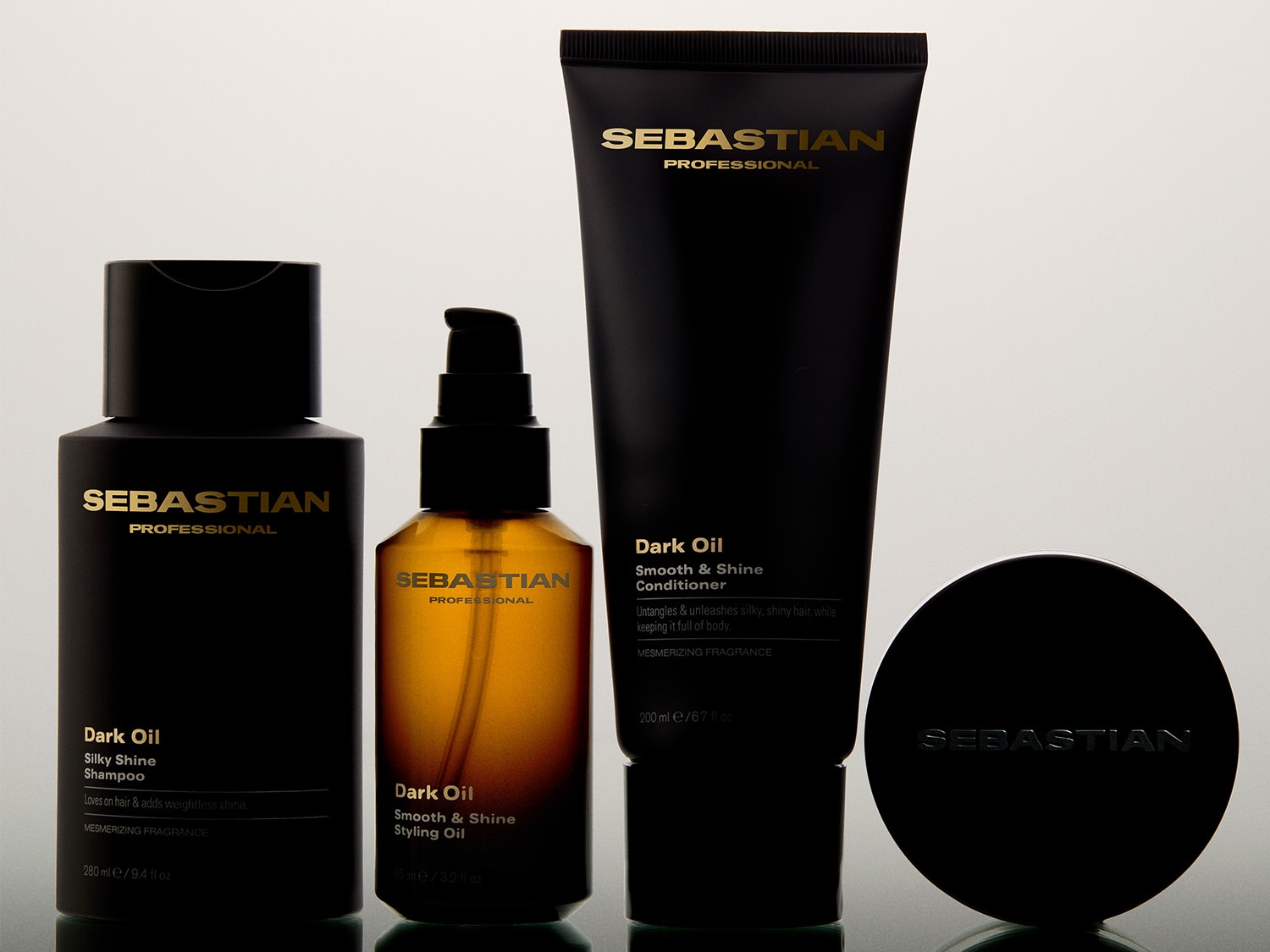 Zestaw Sebastian Professional Dark Oil zawiera szampon Silky Shine, odżywkę Smooth & Shine oraz olejek do stylizacji Smooth & Shine, wszystkie w eleganckich czarnych opakowaniach ze złotymi napisami.
