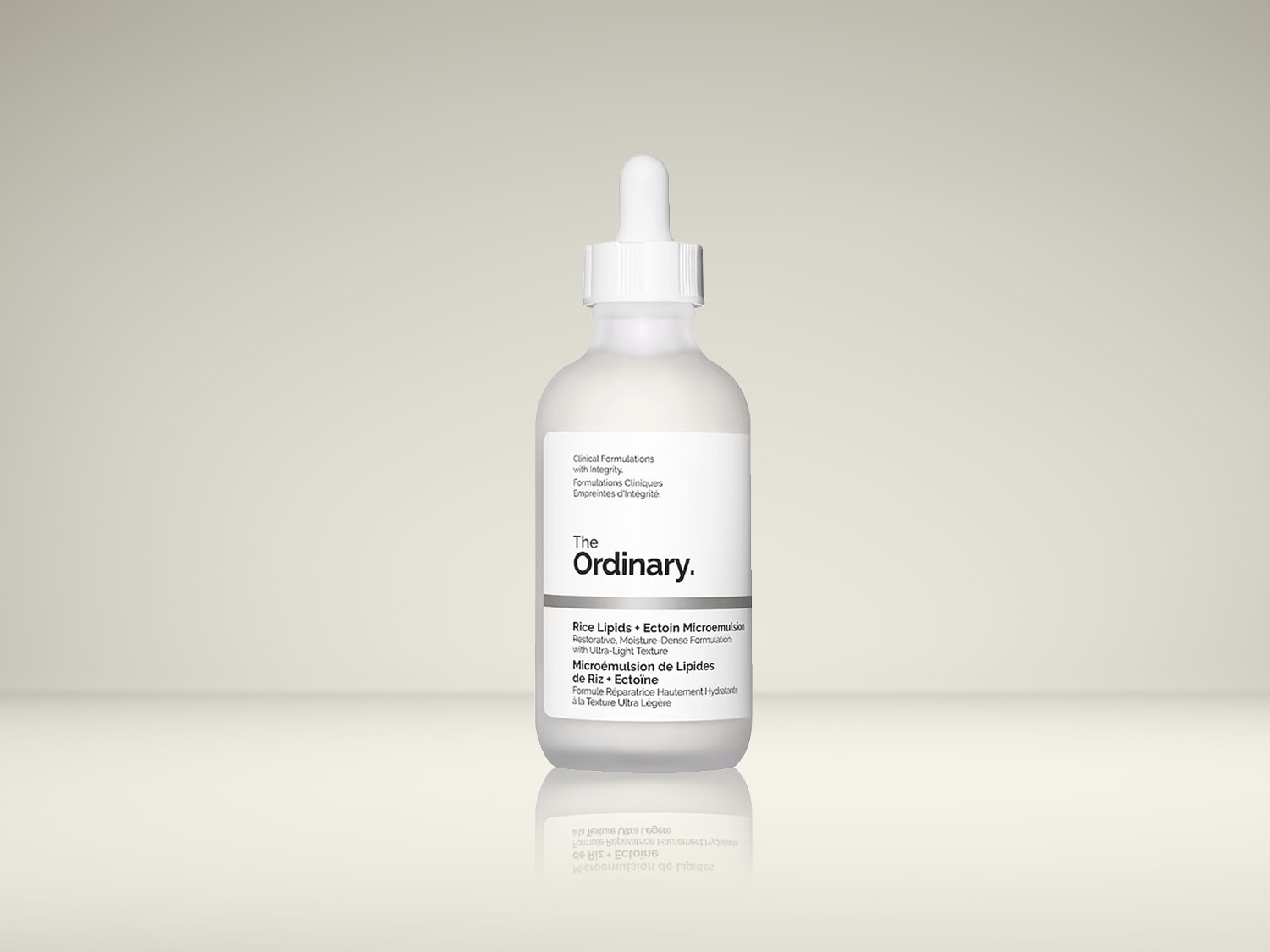 De Ordinary Rice Lipids Ectoin Microemulsion, een herstellende formule met een hoge vochtinbrengende werking en een ultralichte textuur, wordt gepresenteerd in een witte glazen fles met een pipet.