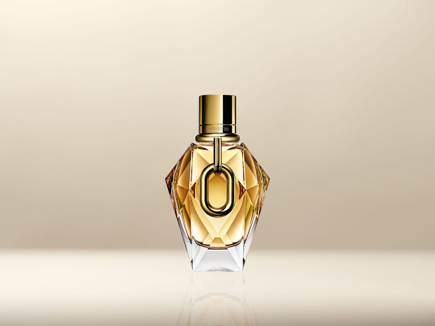 Gouden parfumfles met een uniek, facetgeslepen ontwerp en een gouden dop, straalt luxe en verfijning uit.