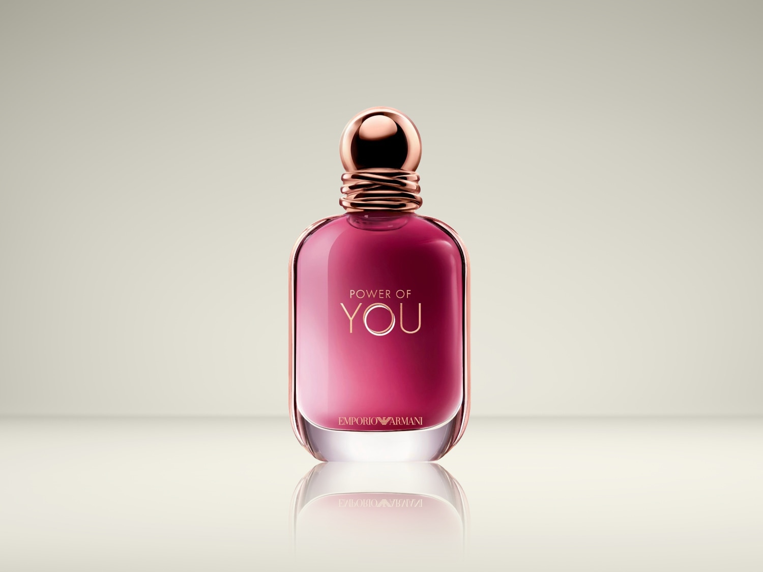 Een elegante, roze parfumfles van Emporio Armani, met de tekst 'Power of You' in gouden letters, straalt luxe en verfijning uit.