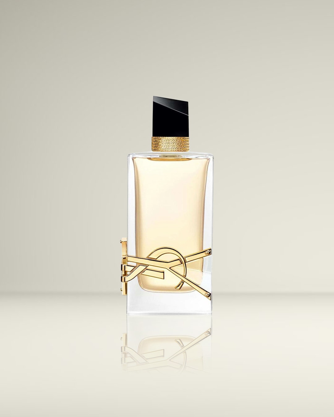 Een elegante, rechthoekige parfumfles met een lichtgele vloeistof, een zwarte dop en een gouden YSL-logo dat om de fles is gewikkeld.