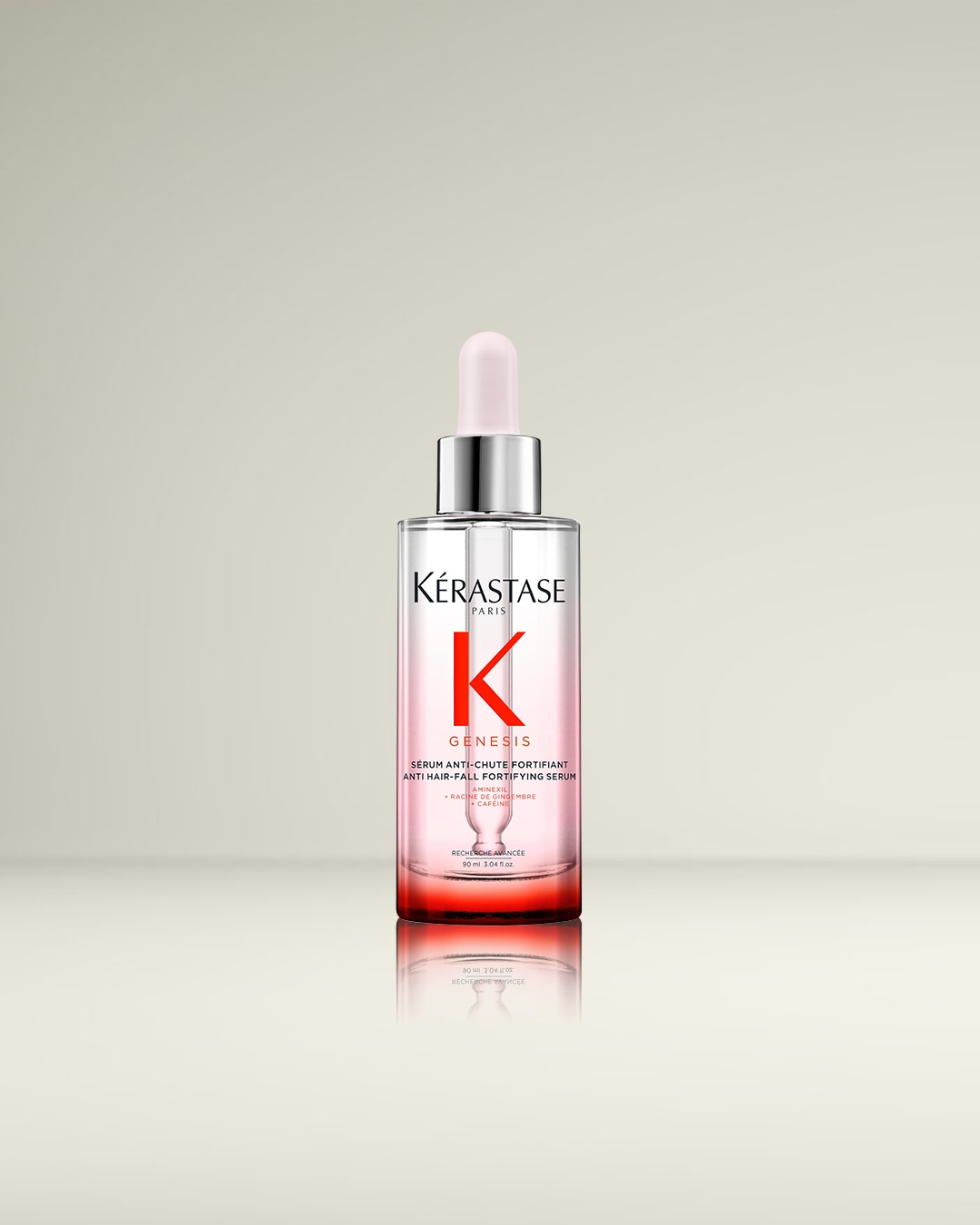 Kérastase Genesis Anti Hair-Fall Fortifying Serum in een transparante fles met roze vloeistof en een zilveren dop met een lichtroze pipet, ontworpen om haaruitval te verminderen.