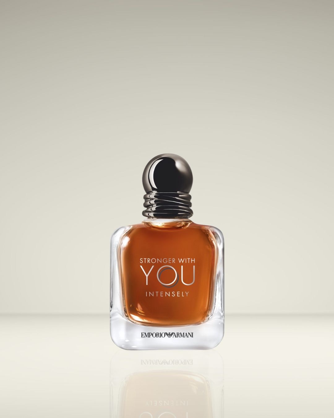 Een vierkante flacon met amberkleurige vloeistof en een zwarte dop, met het opschrift 'Stronger With You Intensely' van Emporio Armani.