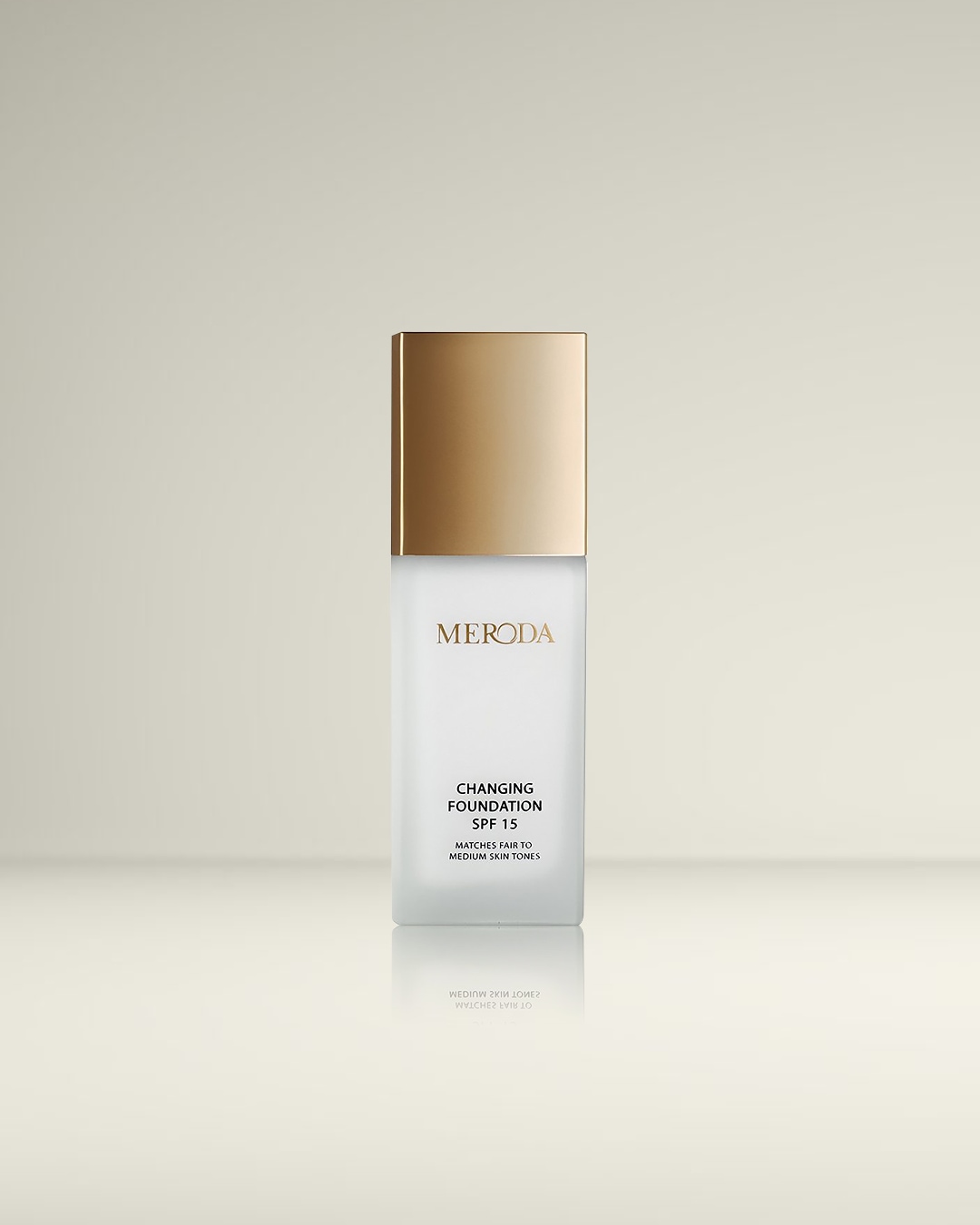 De Meroda Changing Foundation SPF 15 in een matglazen fles met gouden dop, speciaal geformuleerd om zich aan te passen aan lichte tot medium huidtinten.