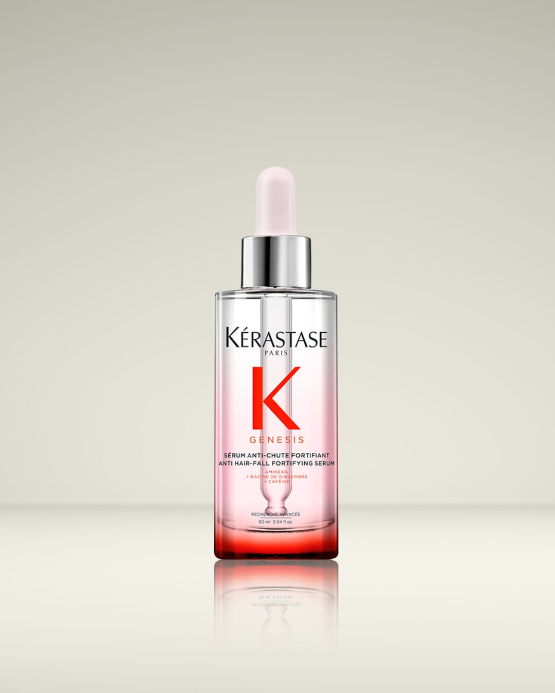 De Kérastase Genesis Anti Hair-Fall Fortifying Serum in een transparante fles met roze vloeistof en een zilveren dop, ontworpen om haaruitval te verminderen en het haar te versterken.