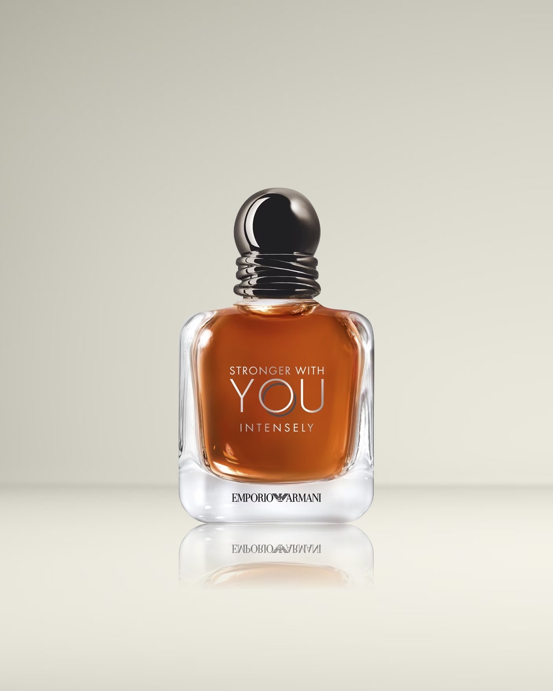 Een vierkante, heldere glazen fles gevuld met amberkleurige vloeistof, getiteld 'Stronger With You Intensely' van Emporio Armani, afgesloten met een glanzende zwarte dop.
