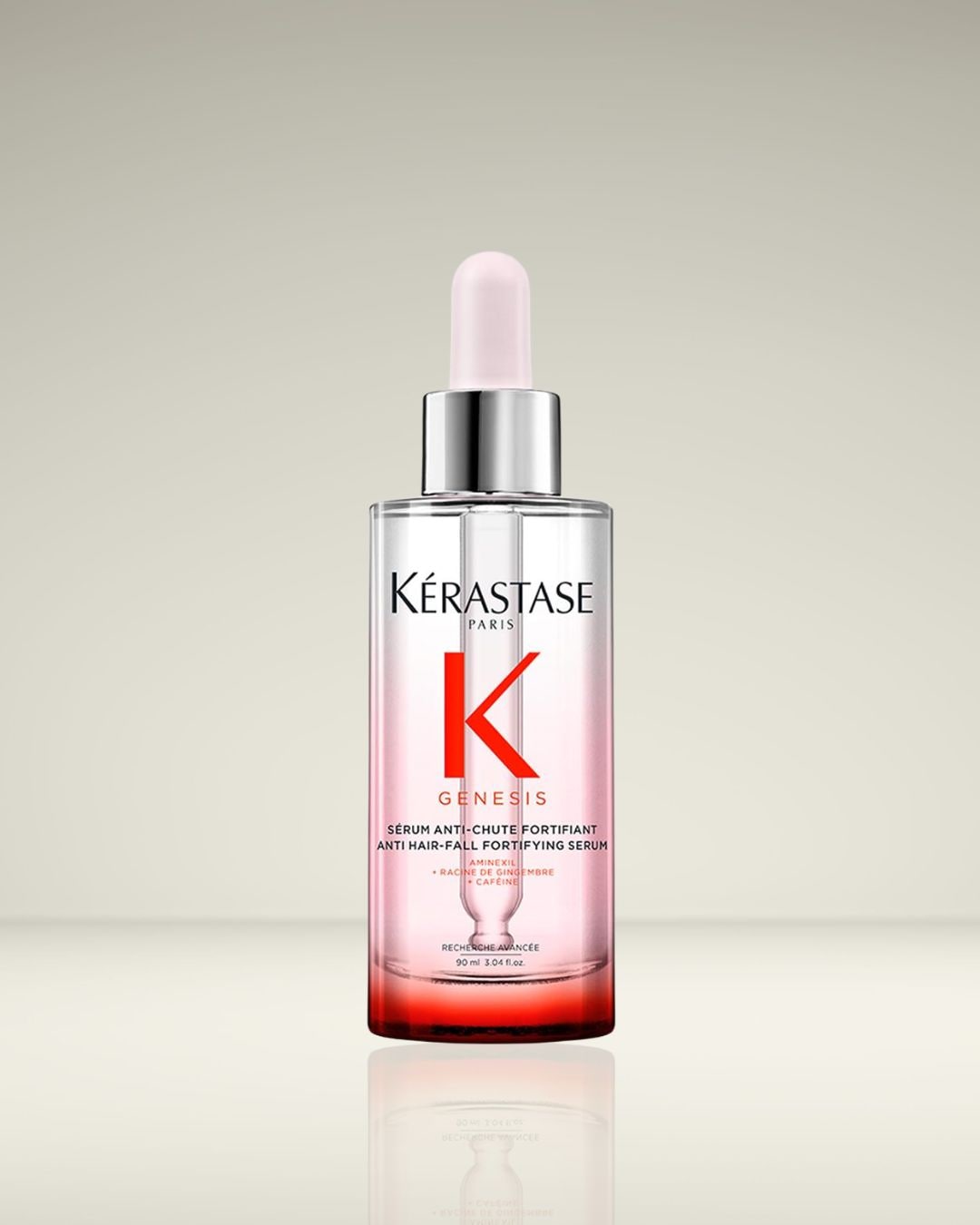 Kérastase Paris Genesis anti-haaruitval versterkend serum in een heldere glazen fles met een zilveren dop en een lichtroze applicator.