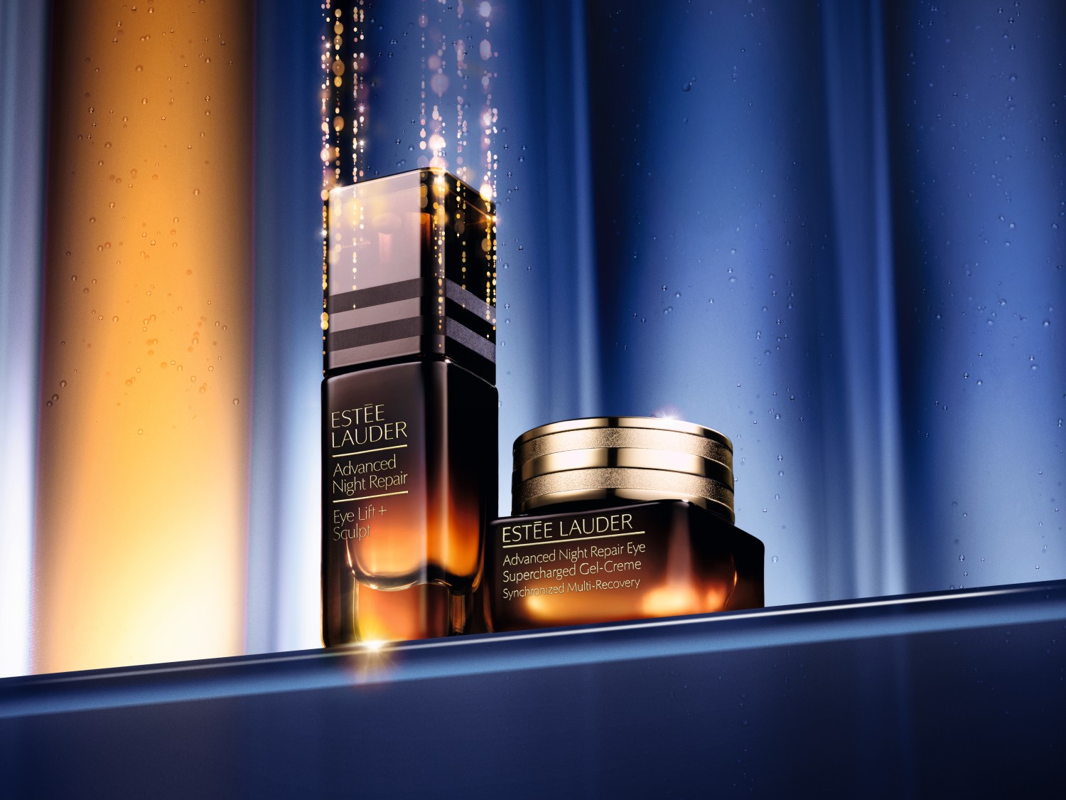 Dwa produkty Estée Lauder Advanced Night Repair: Eye Lift + Sculpt w ciemnej, gradientowej butelce i Supercharged Gel-Creme w słoiczku z złotą nakrętką, obiecujące synchronizowaną multi-regenerację.