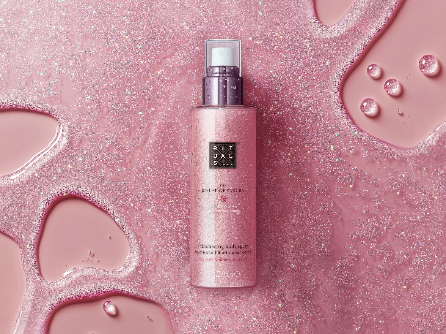 Różowy, połyskujący spray do ciała Rituals The Ritual of Sakura z mlekiem ryżowym i kwiatem wiśni, który rozświetli Twoją skórę.