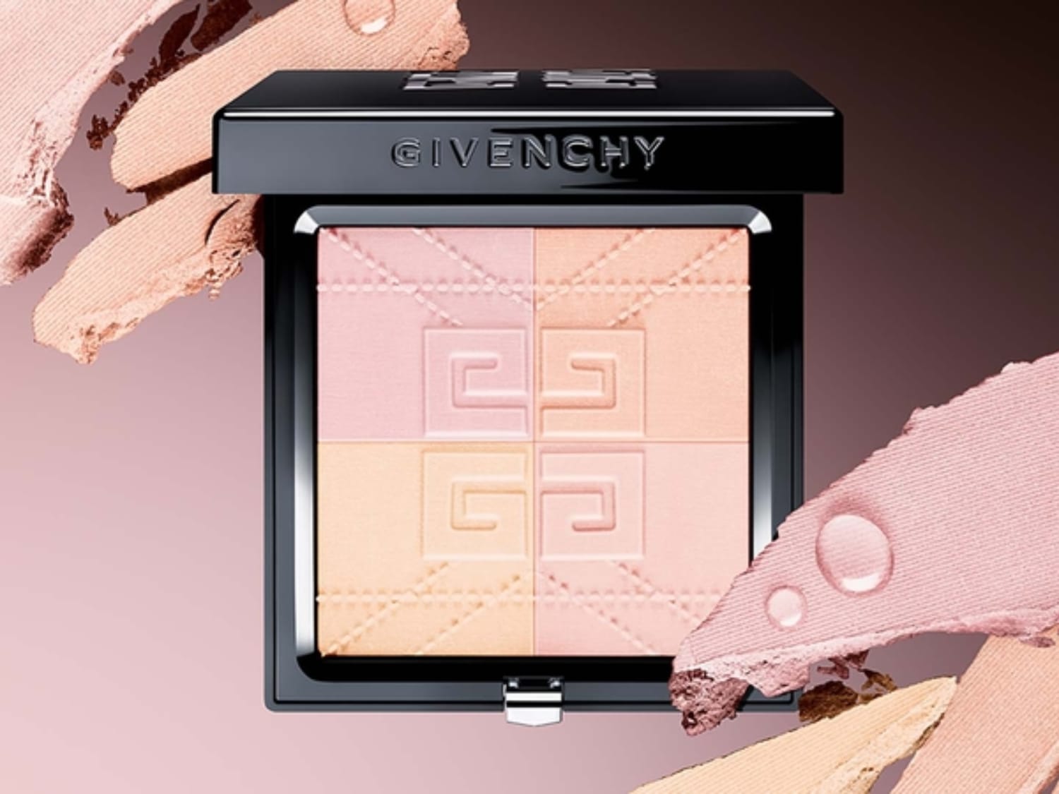 Vier tinten Givenchy-gezichtspoeder in een zwarte compacte verpakking, omgeven door make-upstalen in roze en beige.
