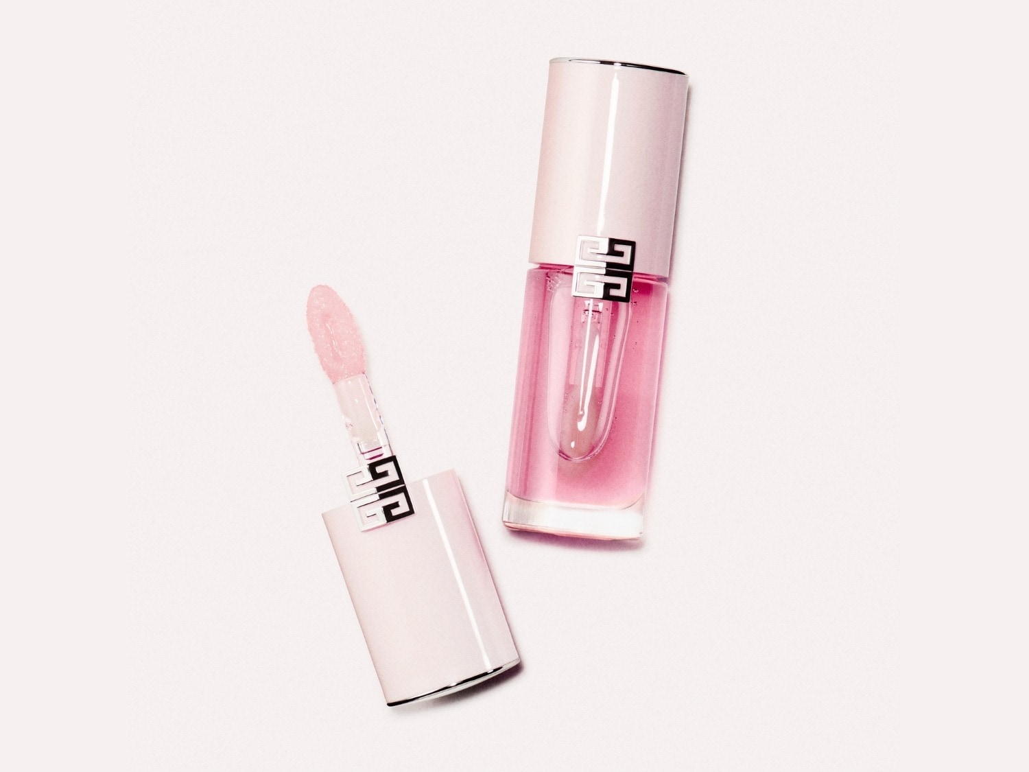Roze lipgloss van Givenchy met een applicator en een transparante dop, klaar om je lippen te laten stralen.