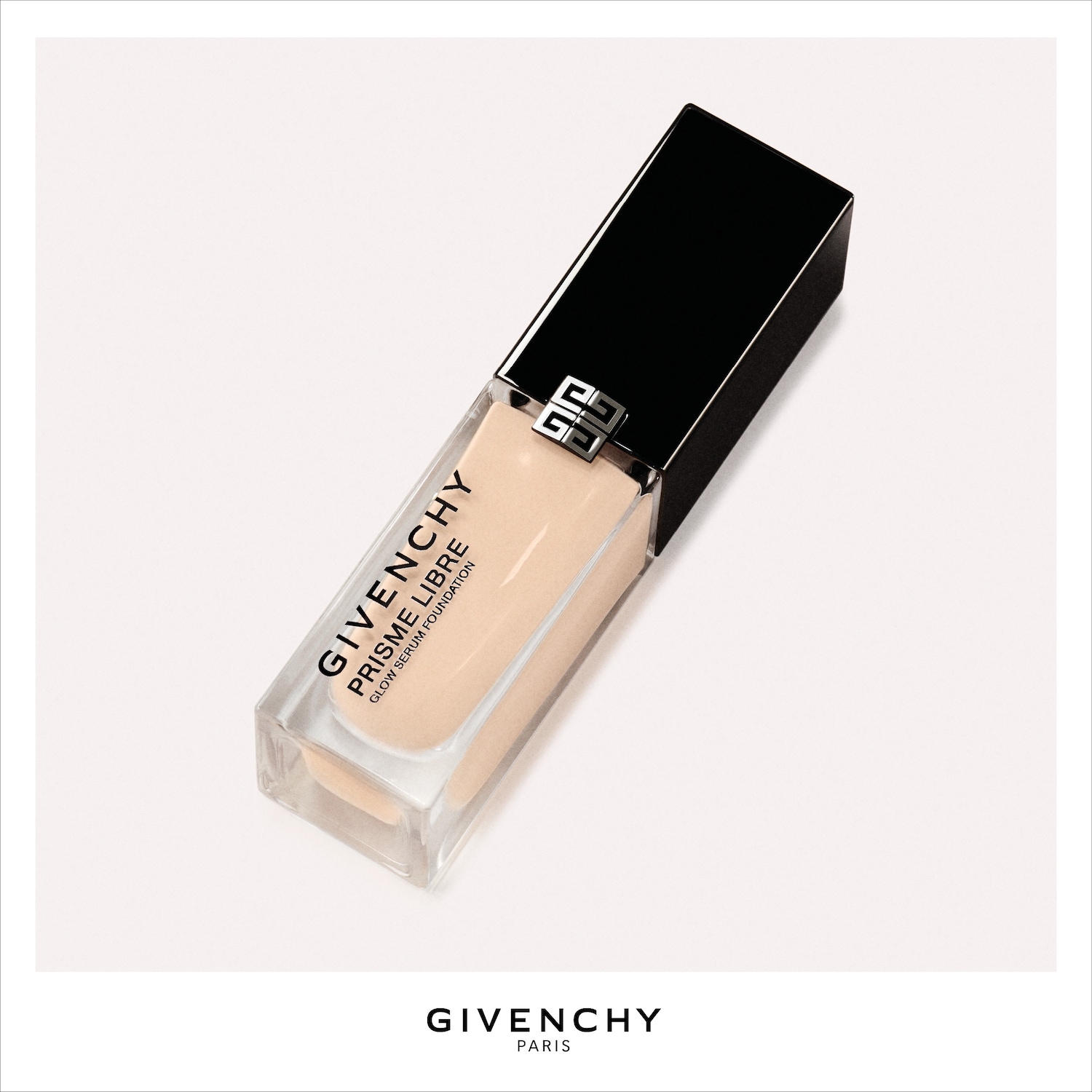 De Givenchy Prisme Libre Glow Serum Foundation in een transparante fles met een zwarte dop, toont een lichte, beige vloeibare foundation.