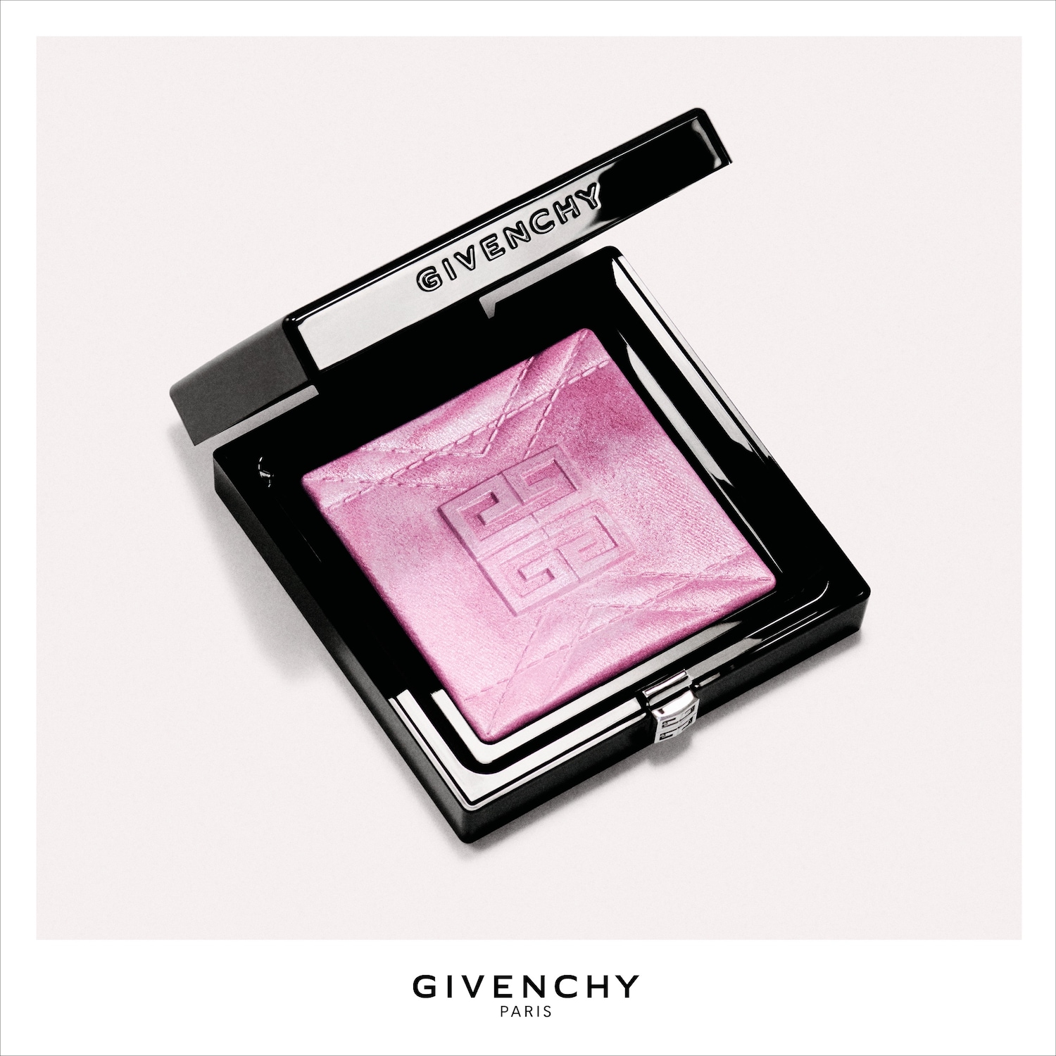 Een open, zwarte compact met een glanzende, roze poeder met het Givenchy-logo in reliëf, klaar om je look te verfraaien.