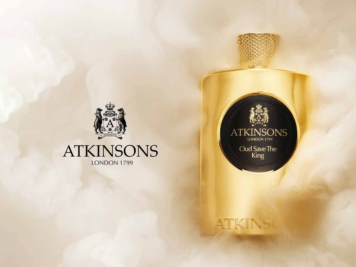 Złota butelka perfum Atkinson's Oud Save The King z czarną etykietą, otoczona mgłą, emanuje luksusem i elegancją.