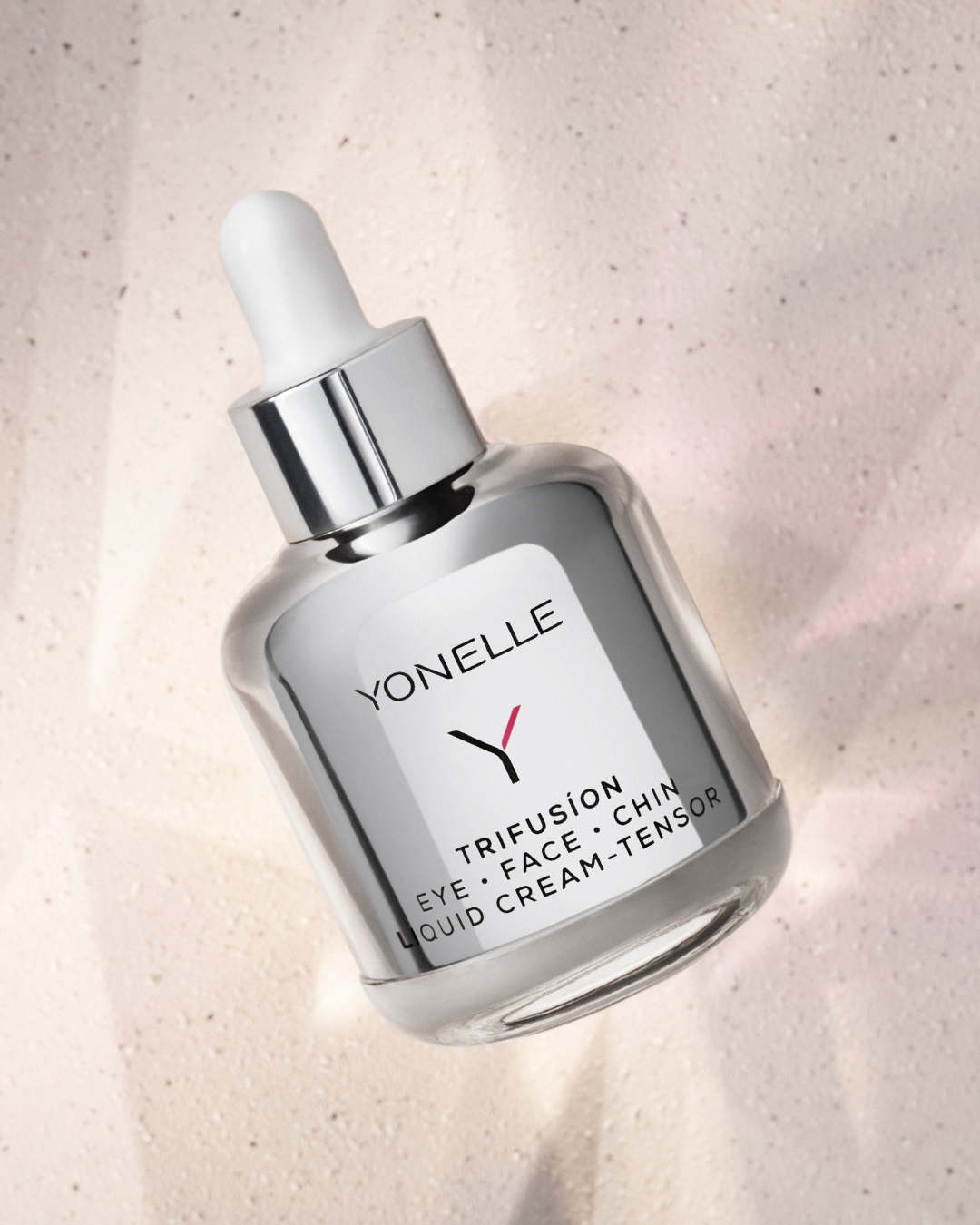 Ezüst színű YONELLE Trifusion folyékony krém-tenzor pipettás üvegben, mely szemre, arcra és állra használható.