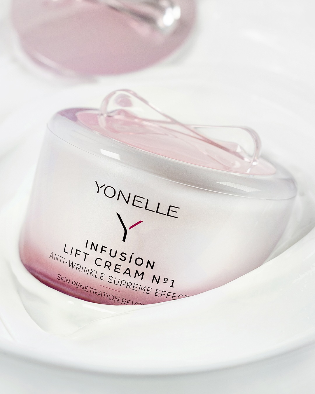 A Yonelle Infusion Lift Cream N°1 ránctalanító krém elegáns, fehér tégelyben, rózsaszín részletekkel, a bőr fiatalítására.