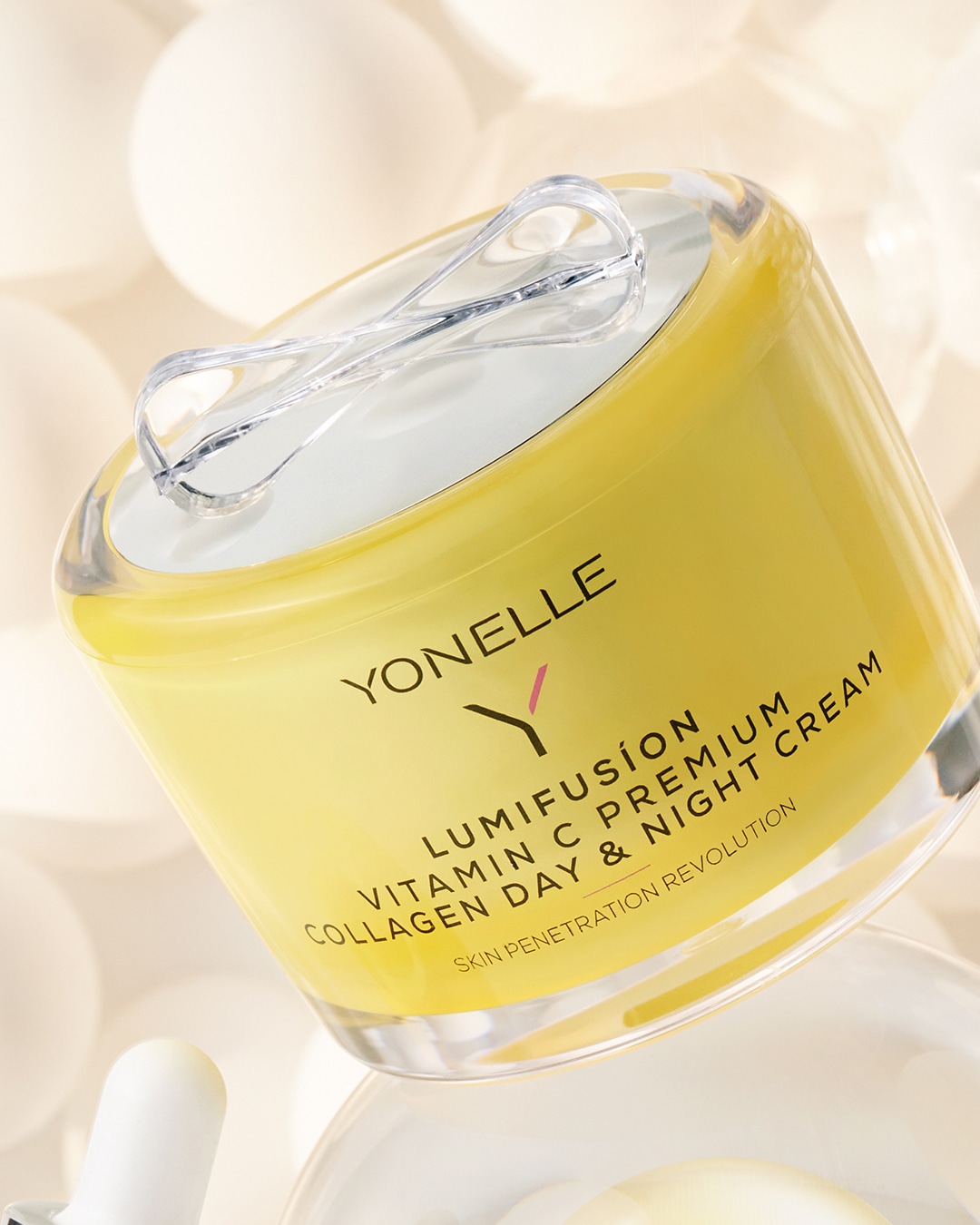 A Yonelle Lumifusion Vitamin C Premium kollagén nappali és éjszakai krém sárga tégelyben, átlátszó fedéllel.