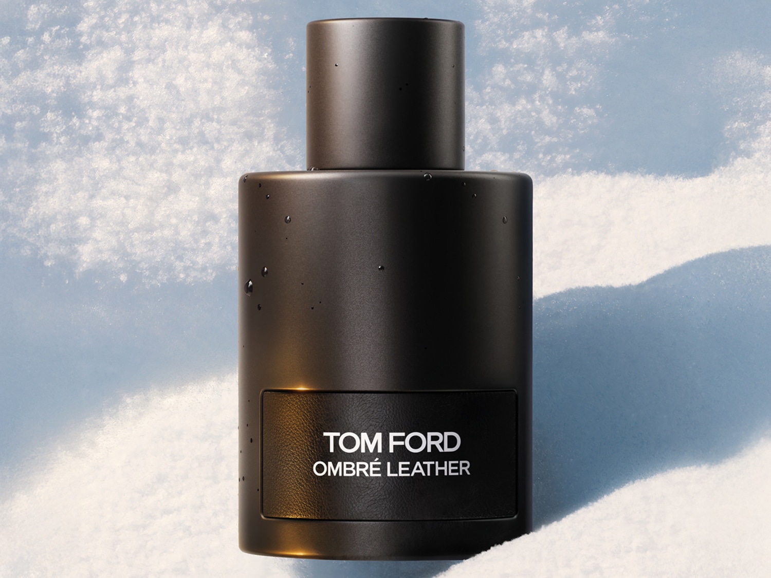 Flacone nero opaco di Tom Ford Ombré Leather su sfondo innevato, che evoca un profumo intenso e sofisticato.