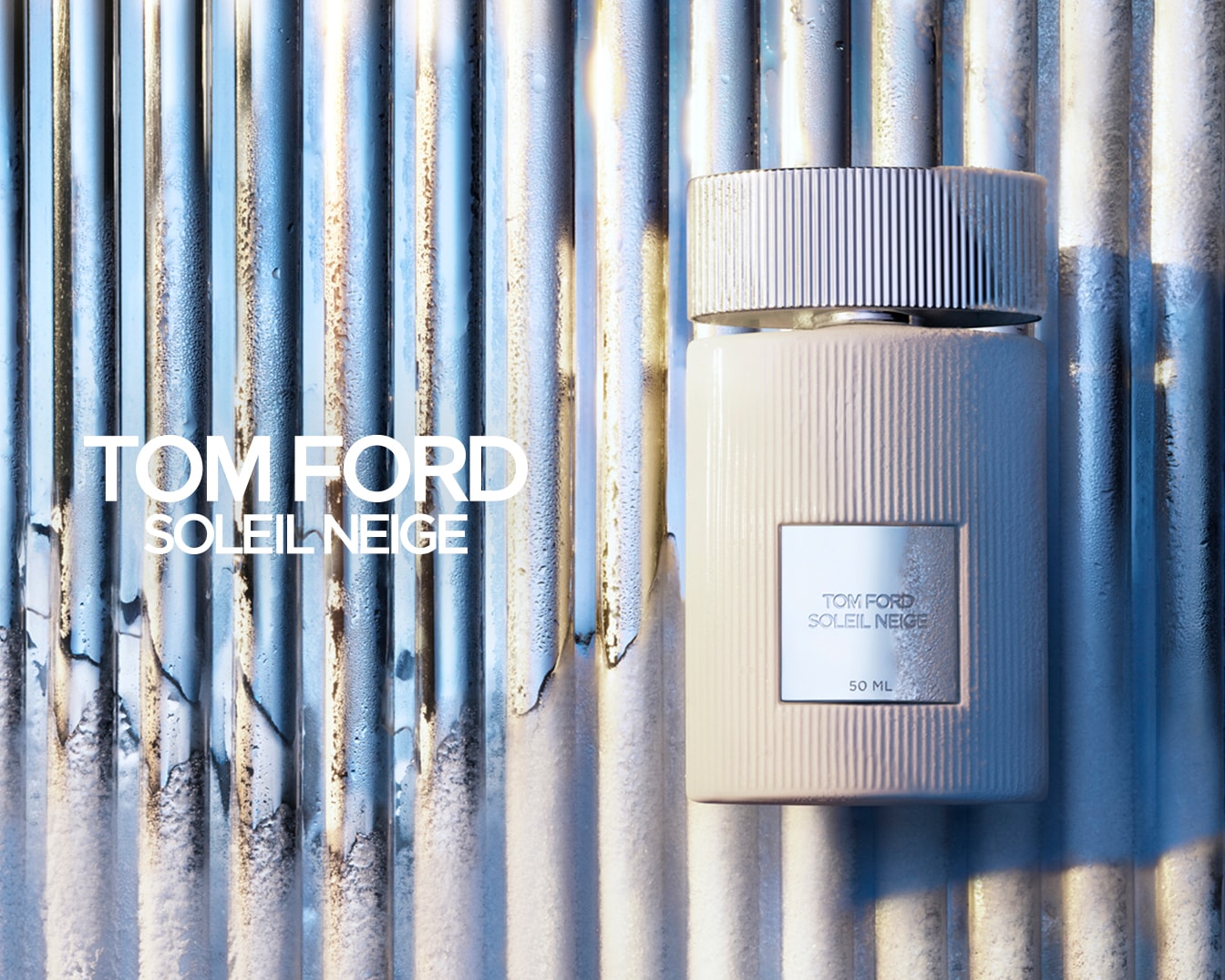 Flacone di profumo Tom Ford Soleil Neige color crema con tappo argentato su sfondo metallico ondulato.