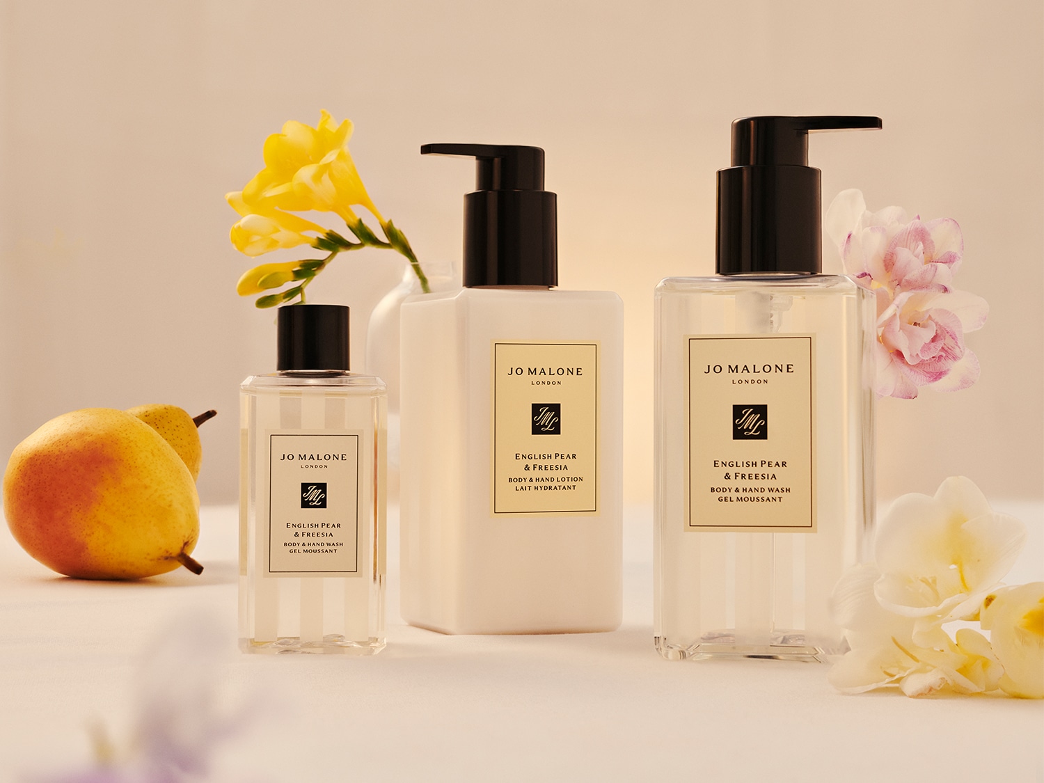 Drie zwarte Jo Malone flessen met pompjes, elk gevuld met luxe bad- en lichaamsproducten.
