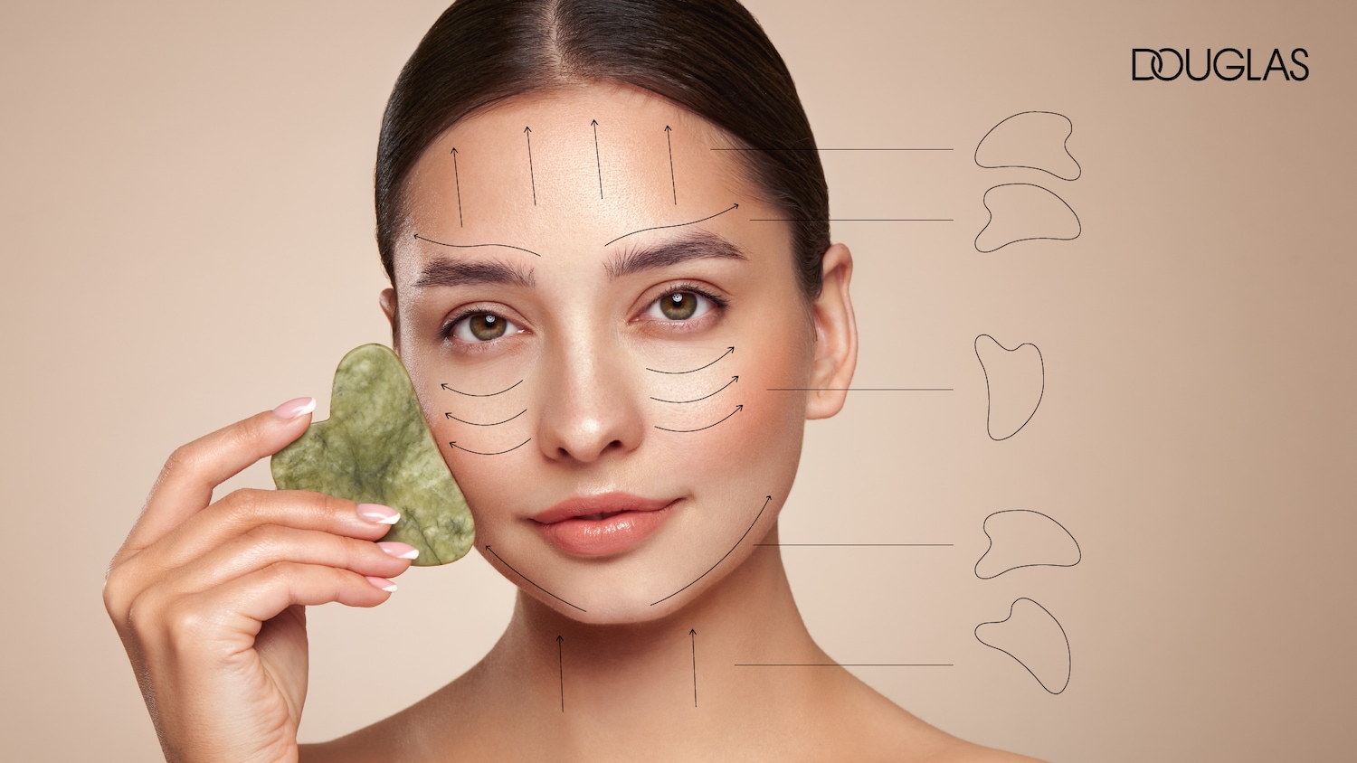 Pohľadná žena drží v ruke zelený gua sha kameň, ktorý sa používa na masáž tváre, s vyznačenými líniami ťahov pre dosiahnutie liftingu a relaxácie pleti.