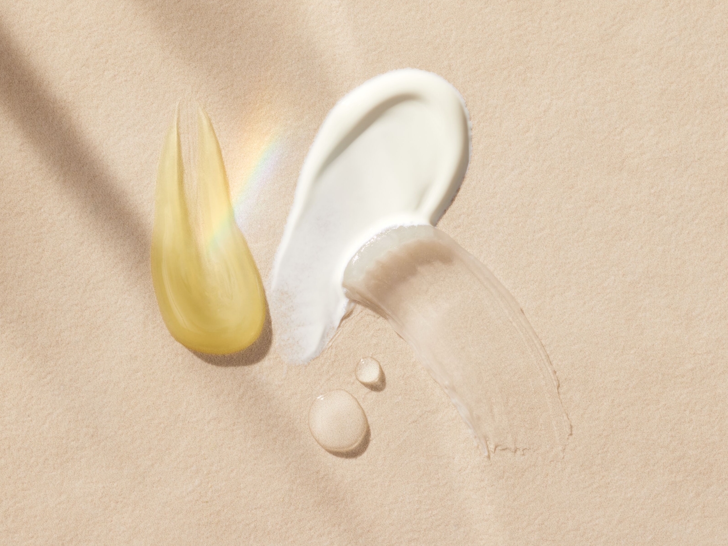 Verschiedene Texturen von Hautpflegeprodukten, darunter ein gelbes Öl, eine weiße Creme und ein transparentes Gel, die auf einem beigen Hintergrund aufgetragen sind.