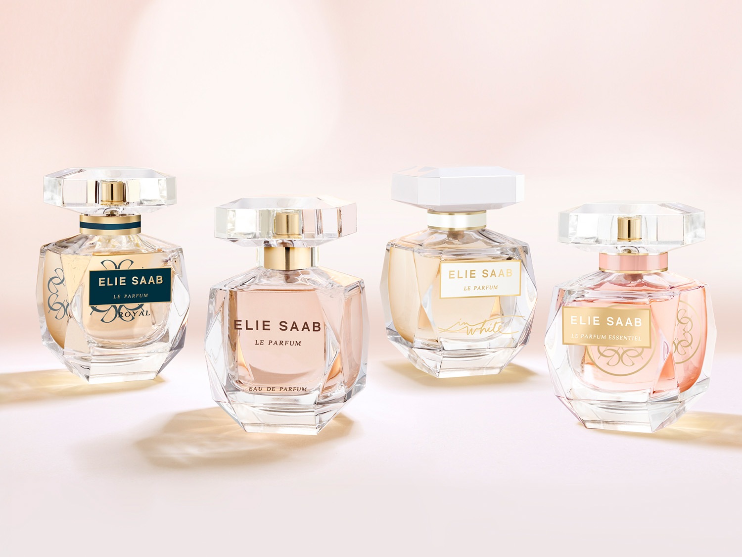 Vier flessen Elie Saab parfum, elk met een unieke geur en verpakt in een heldere, facetgeslepen glazen fles met een geometrische dop.