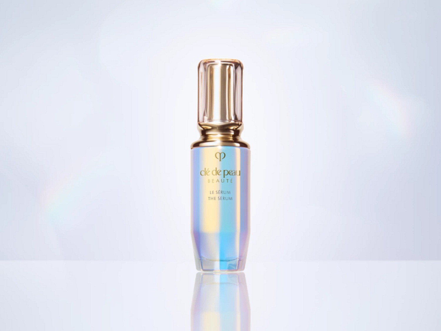 Découvrez le sérum Clé de Peau Beauté dans un flacon irisé avec un bouchon doré, promettant une peau éclatante et revitalisée.