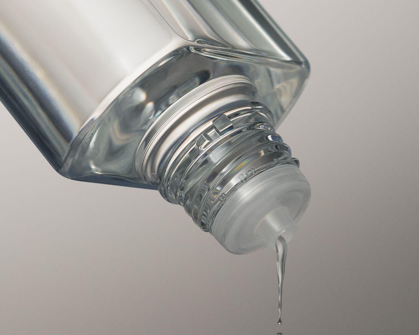 Przezroczysta butelka z płynem wylewającym się z niej, ukazująca czystość i lekkość produktu.