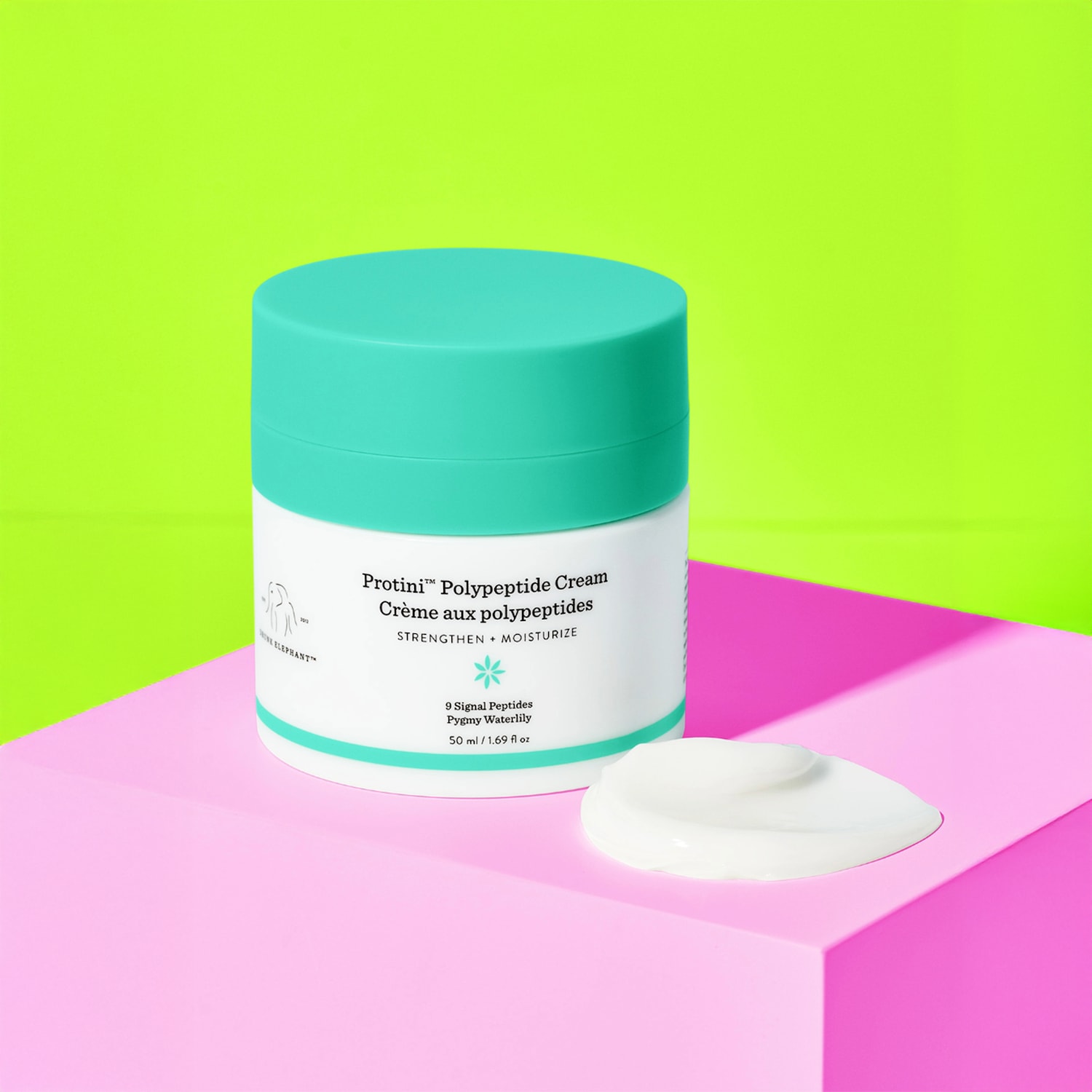 De Protini™ Polypeptide Cream van Drunk Elephant in een witte pot met een turquoise deksel, belooft de huid te versterken en te hydrateren met 9 signaalpeptiden en pygmee waterlelie.