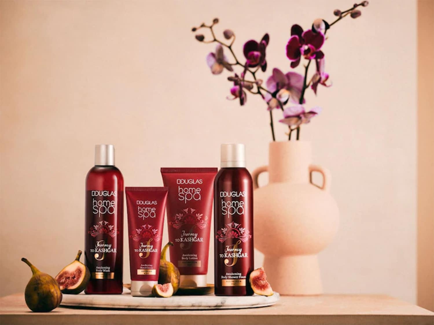 Scopri la collezione Douglas Home Spa Journey to Kashgar, con flaconi rosso scuro e decorazioni floreali, per un'esperienza sensoriale unica.