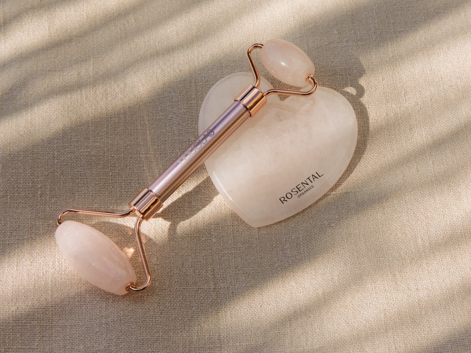 Rullo di quarzo rosa con manico color oro rosa e pietra a forma di cuore per massaggiare delicatamente la pelle del viso.