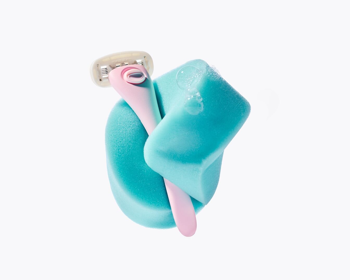 Una esponja azul brillante sostiene una maquinilla de afeitar rosa pálido, lista para una depilación suave y eficaz.