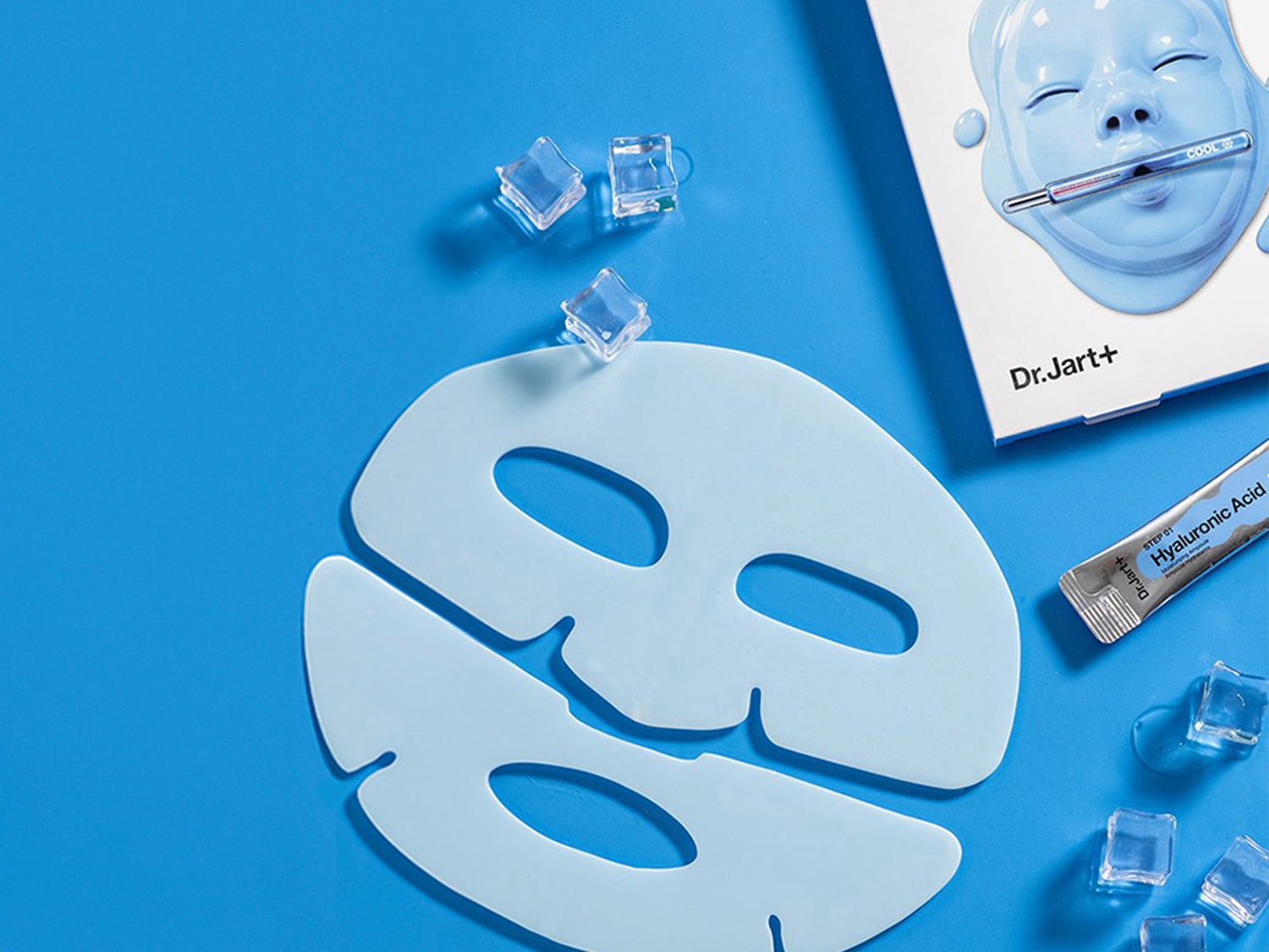 Masque facial bleu clair Dr.Jart+ avec emballage et sérum d'acide hyaluronique sur fond bleu, agrémenté de quelques glaçons.