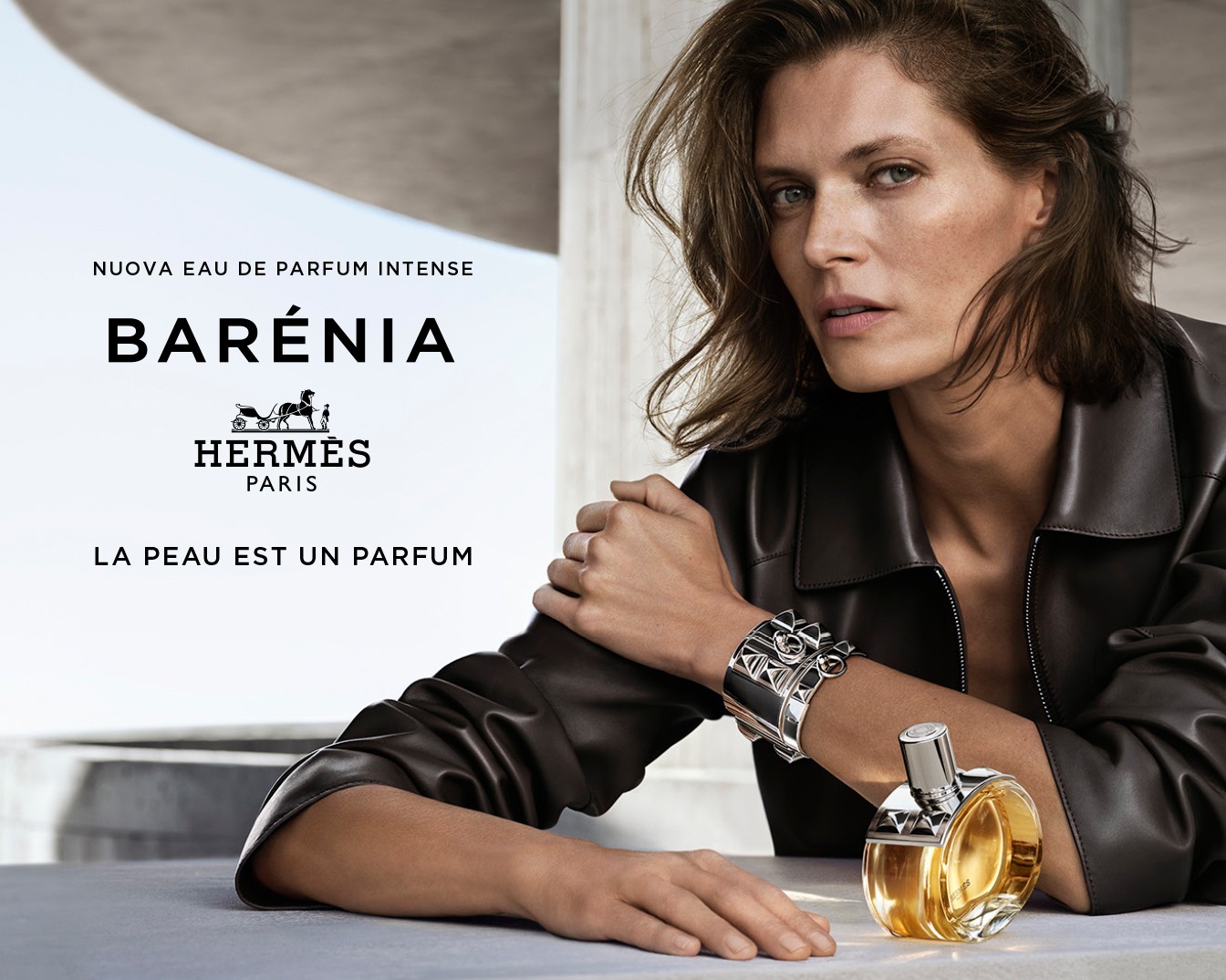 L'immagine mostra una bottiglia di profumo Terre d'Hermès Eau de Parfum Intense con un uomo di profilo e una formazione rocciosa sullo sfondo, evocando un senso di natura e mascolinità.