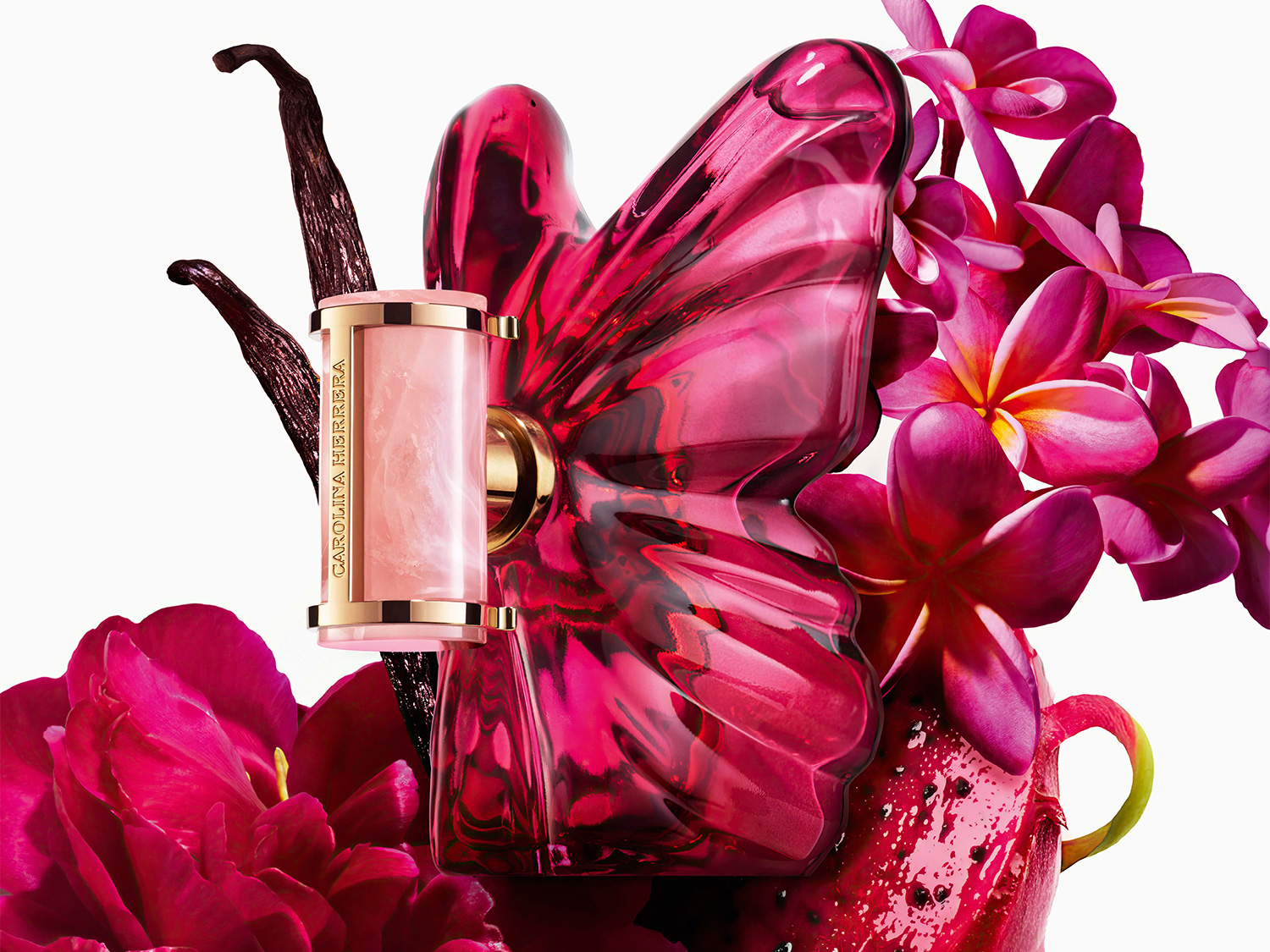 El perfume Carolina Herrera se presenta en un frasco rosa con forma de mariposa, adornado con flores rosas y vainas de vainilla.