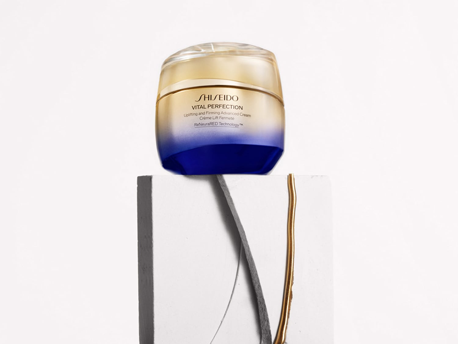 Il vasetto di crema Shiseido Vital Perfection, con sfumature dorate e blu, promette un effetto lifting e rassodante per una pelle visibilmente più giovane.