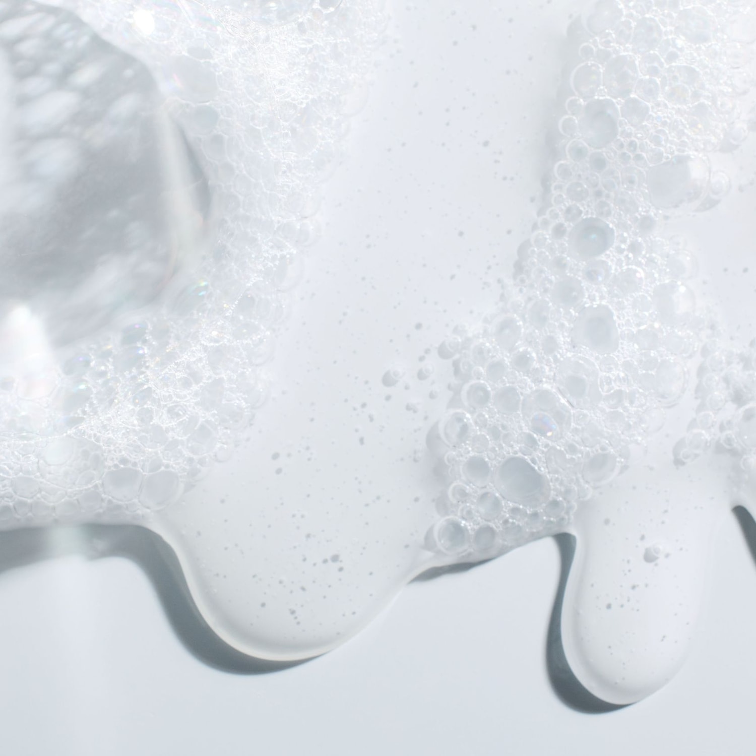 Primo piano di una texture bianca e spumosa, con bolle che creano un effetto di pulizia e freschezza.