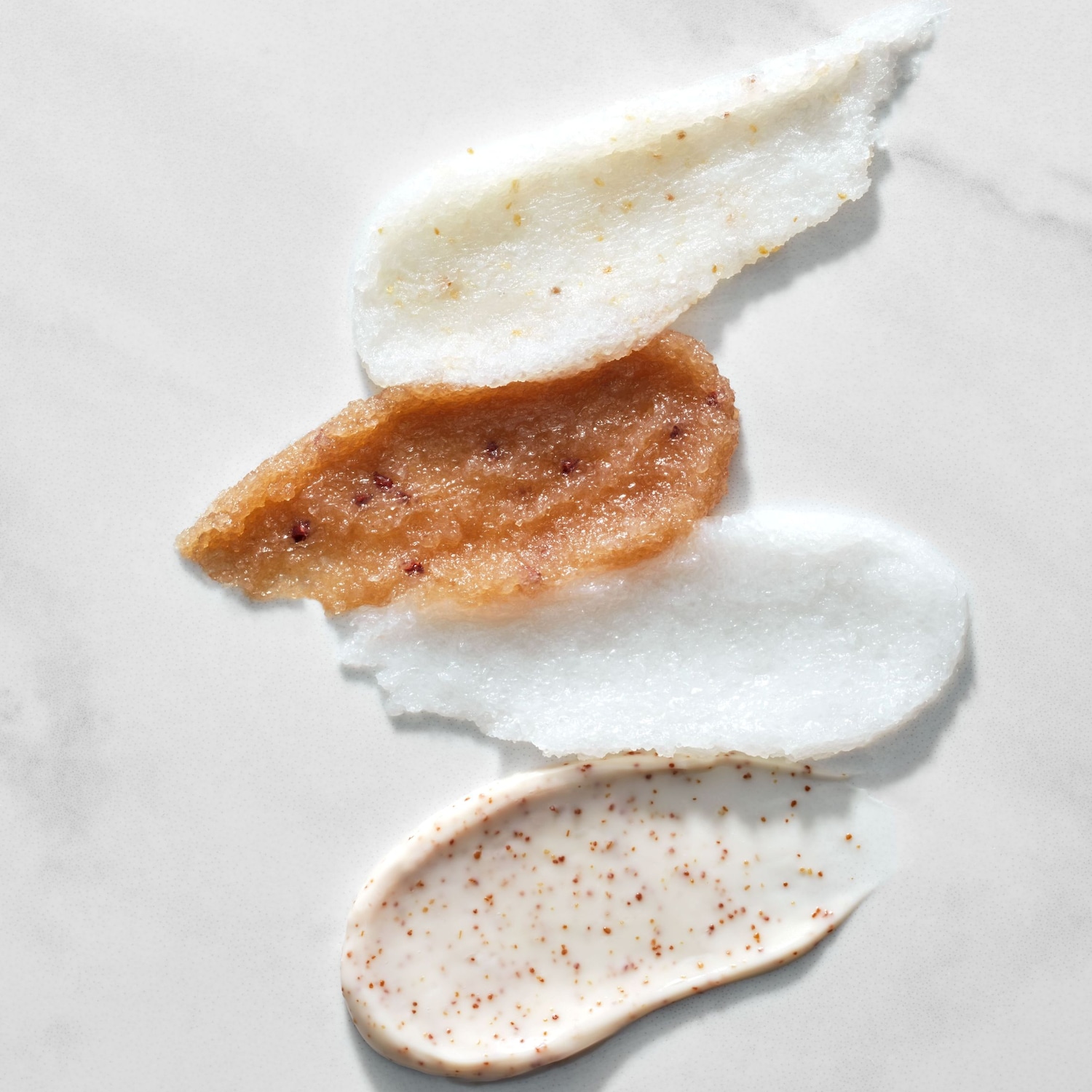 Ecco quattro diversi scrub cremosi, ognuno con una consistenza e un colore unici, perfetti per esfoliare e rivitalizzare la pelle.