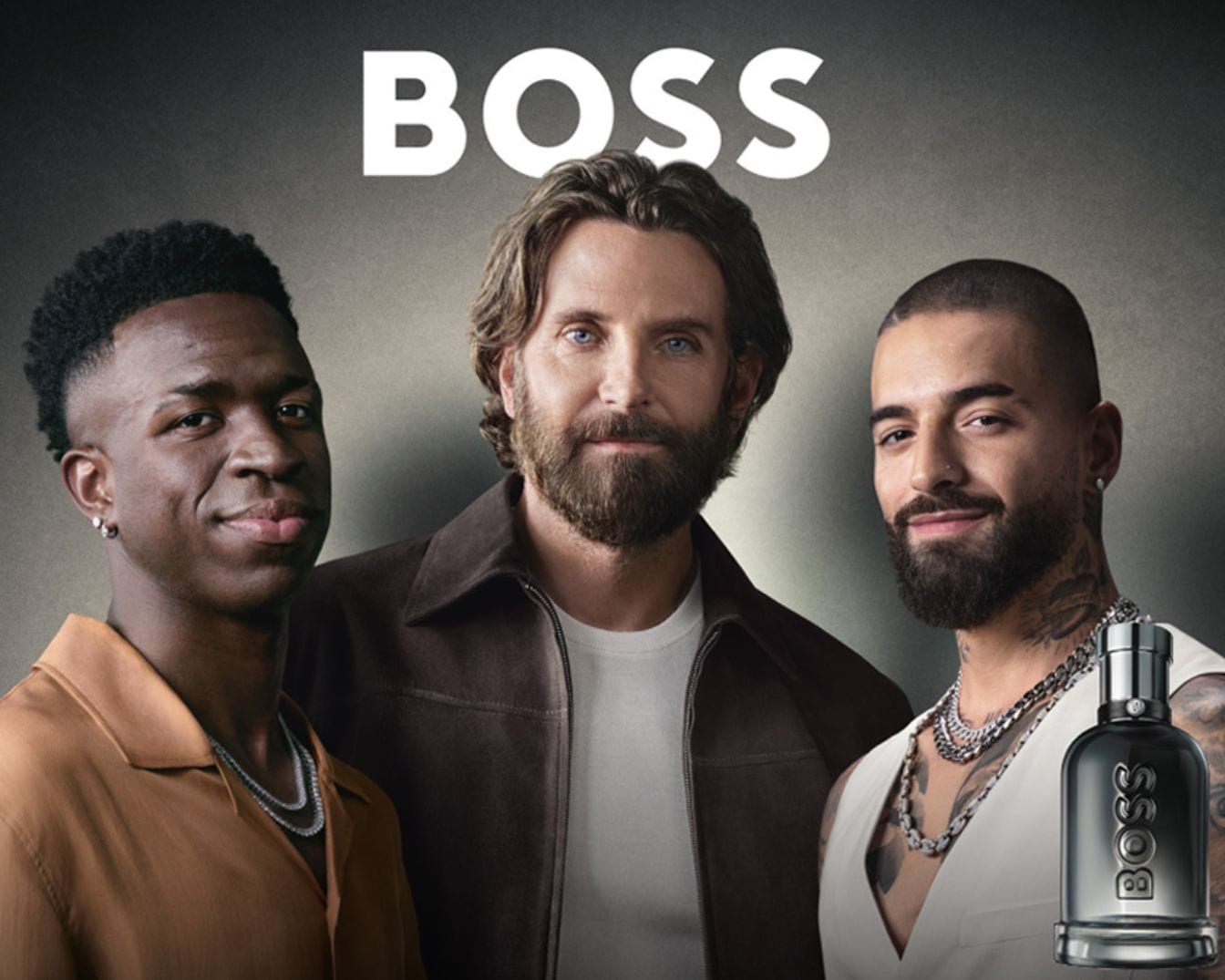 Tváře kampaně BOSS: Vinícius Júnior, Bradley Cooper a Maluma pózují vedle flakonu parfému BOSS, který ztělesňuje sílu a úspěch.