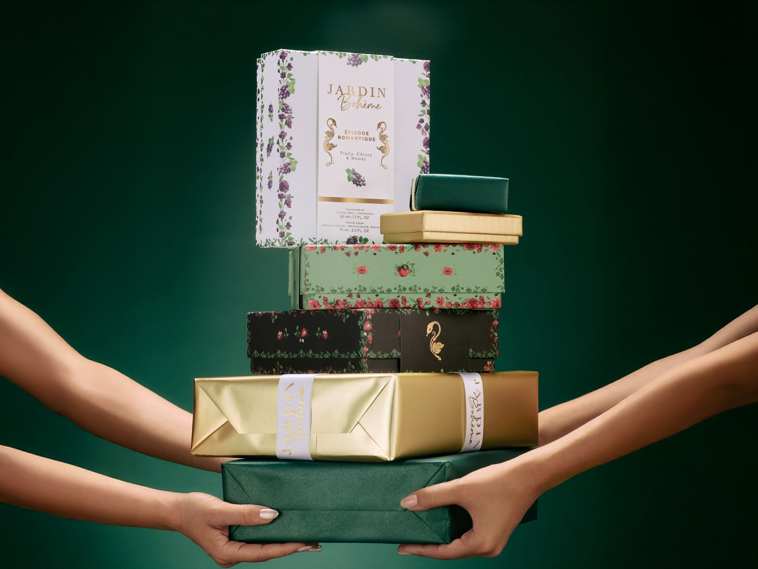 Une pile de cadeaux joliment emballés dans des papiers aux motifs floraux et aux couleurs or et vert forêt, tenus par des mains délicates, évoquant l'élégance des fêtes.