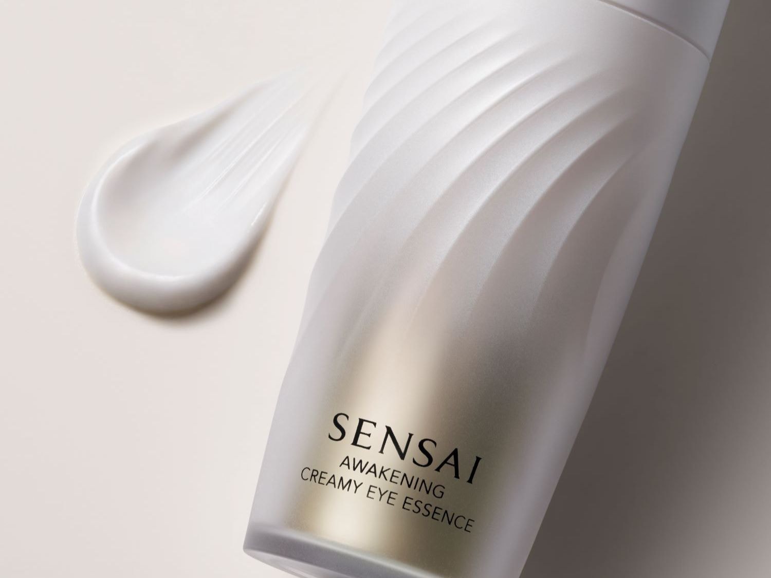 Detailní záběr na bílý krém Sensai Awakening Creamy Eye Essence s elegantním bílým obalem a hladkou texturou.
