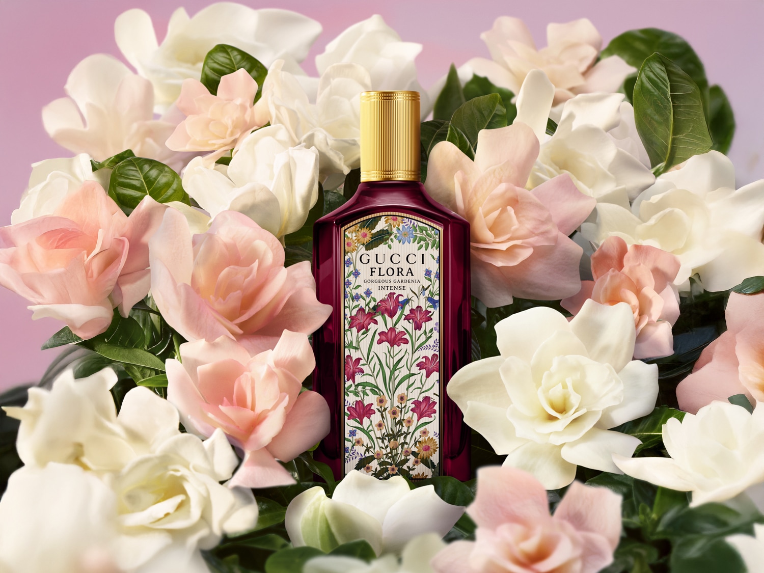 Žltý flakón Gucci Flora Gorgeous Orchid obklopený bielymi kvetmi a vanilkovými strukmi vytvára sviežu a elegantnú kompozíciu.