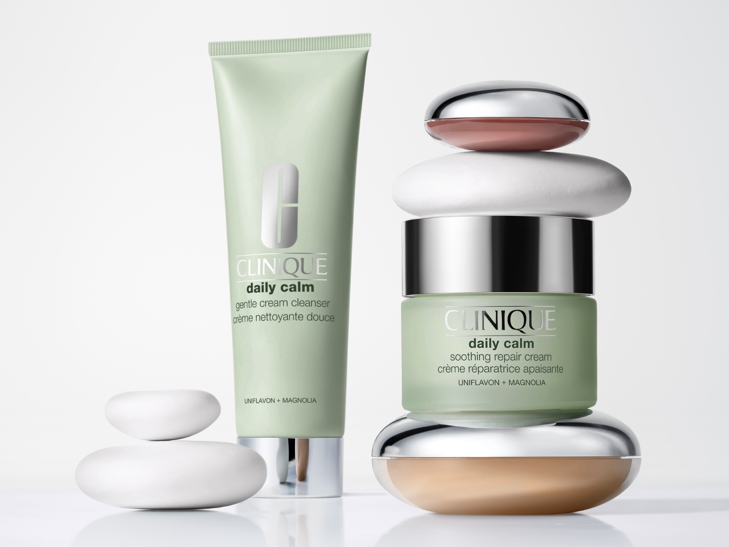 Zklidňující krémový čisticí přípravek Clinique Daily Calm a zklidňující opravný krém s Uniflavonem a Magnolií jsou prezentovány v jemných zelených obalech, doplněných dekorativními kameny.