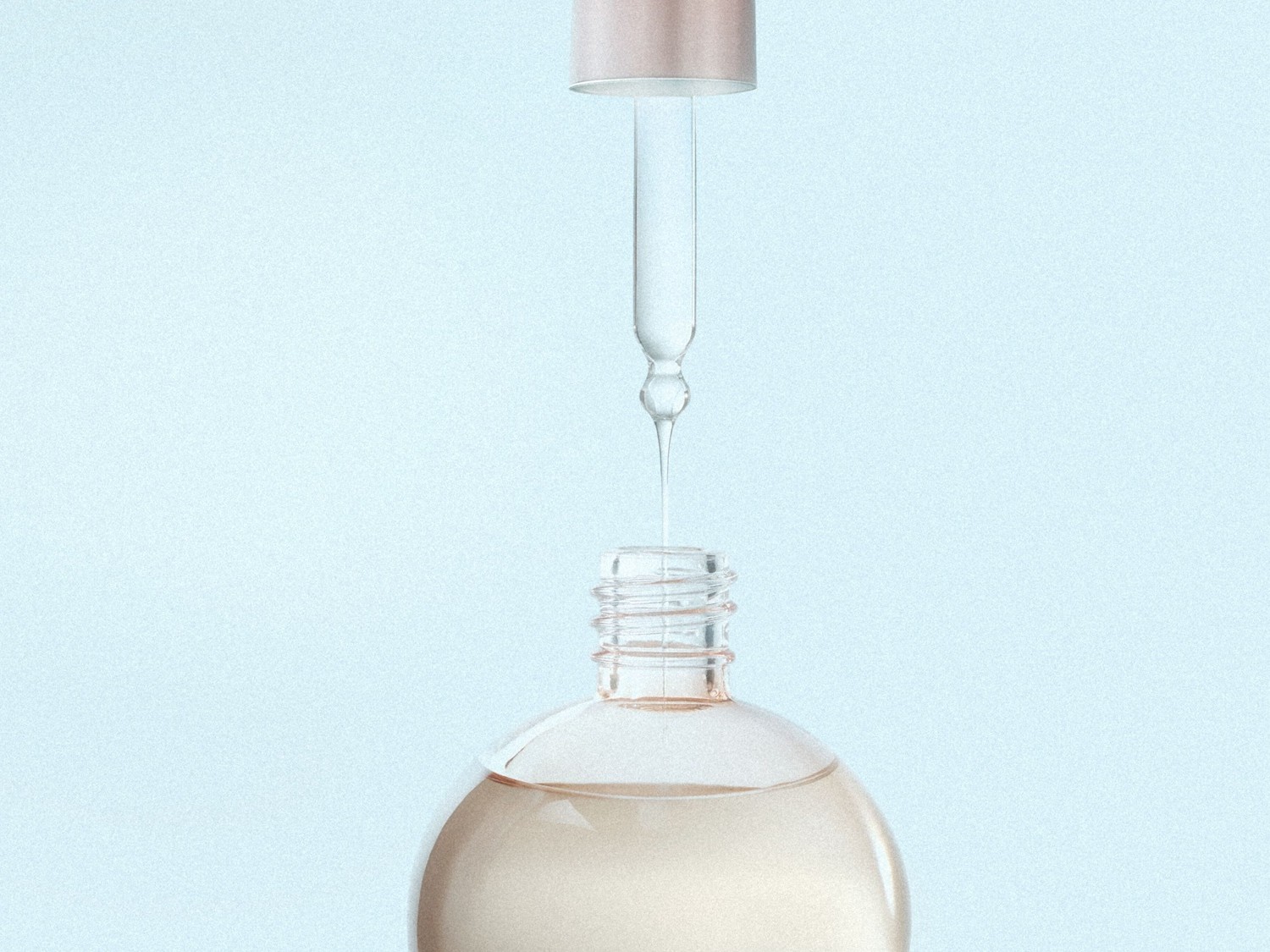 Close-up van een heldere glazen fles met een lichtroze dop en een glazen pipet die een druppel serum afgeeft, tegen een zachtblauwe achtergrond.