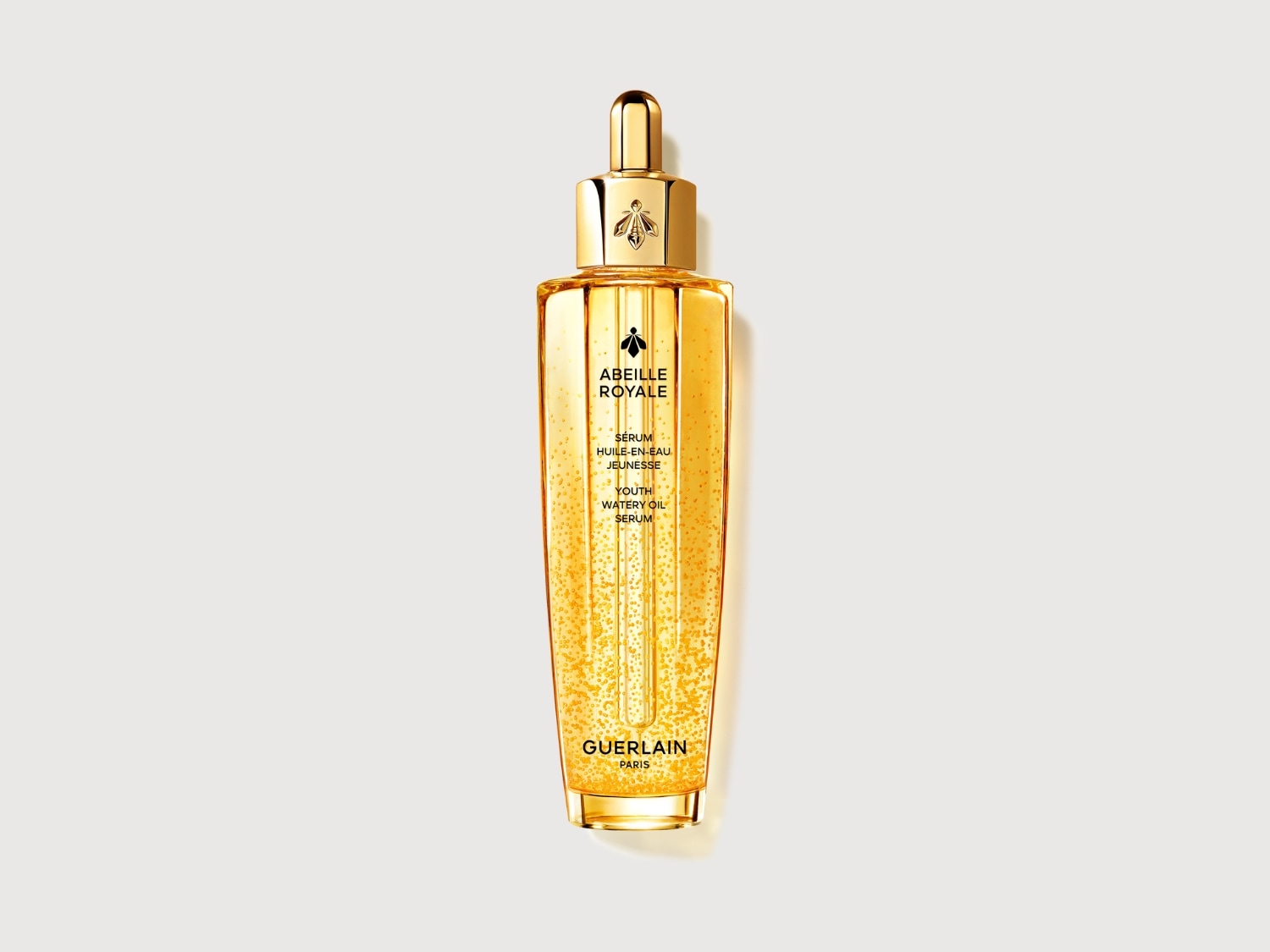 El sérum Abeille Royale de Guerlain, un aceite acuoso para la juventud, viene en un frasco dorado con un aplicador tipo gotero y el logo de la abeja.