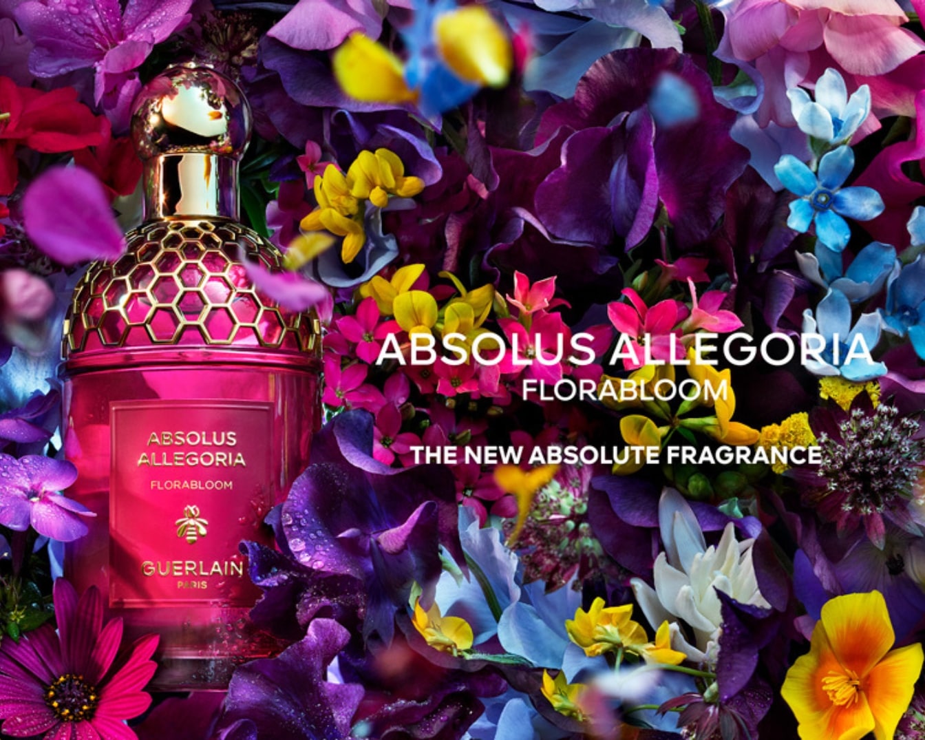 Descubre Absolus Allegoria Florabloom, la nueva fragancia absoluta de Guerlain, en un frasco rosa con detalles dorados, rodeado de un vibrante jardín floral.