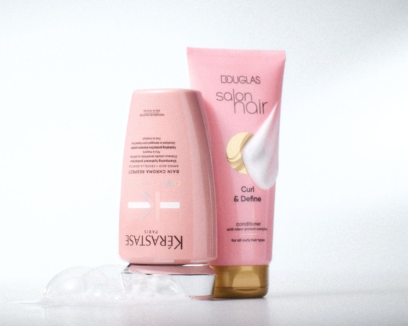 Rosa Shampoo und Spülung von Kérastase und Douglas Salon Hair für lockiges Haar, die Feuchtigkeit spenden und die Locken definieren.